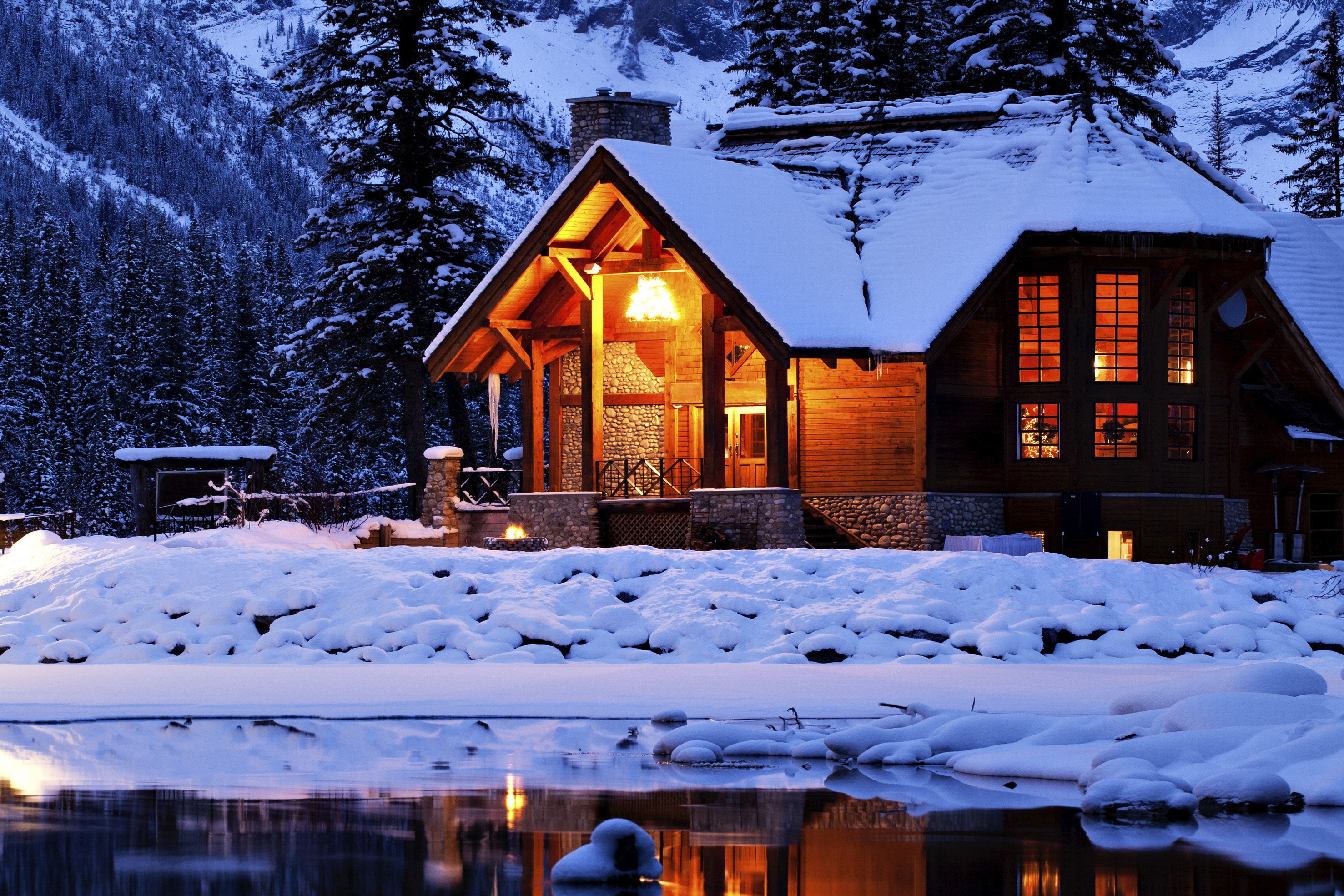 Cozy wooden cabin by a frozen lake in winter HD Wallpaper