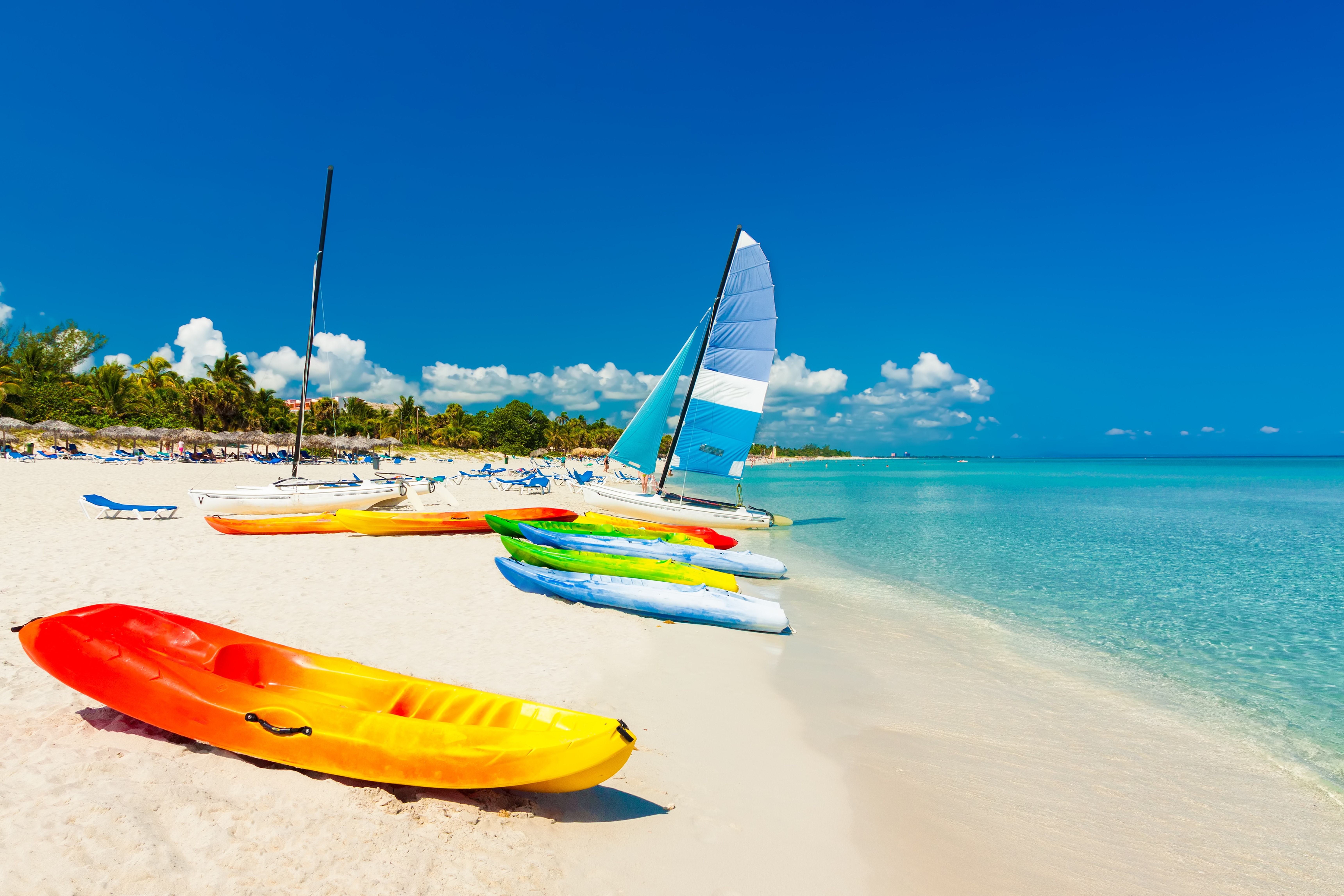 Kayaks and sailboats on a tropical beach HD Wallpaper