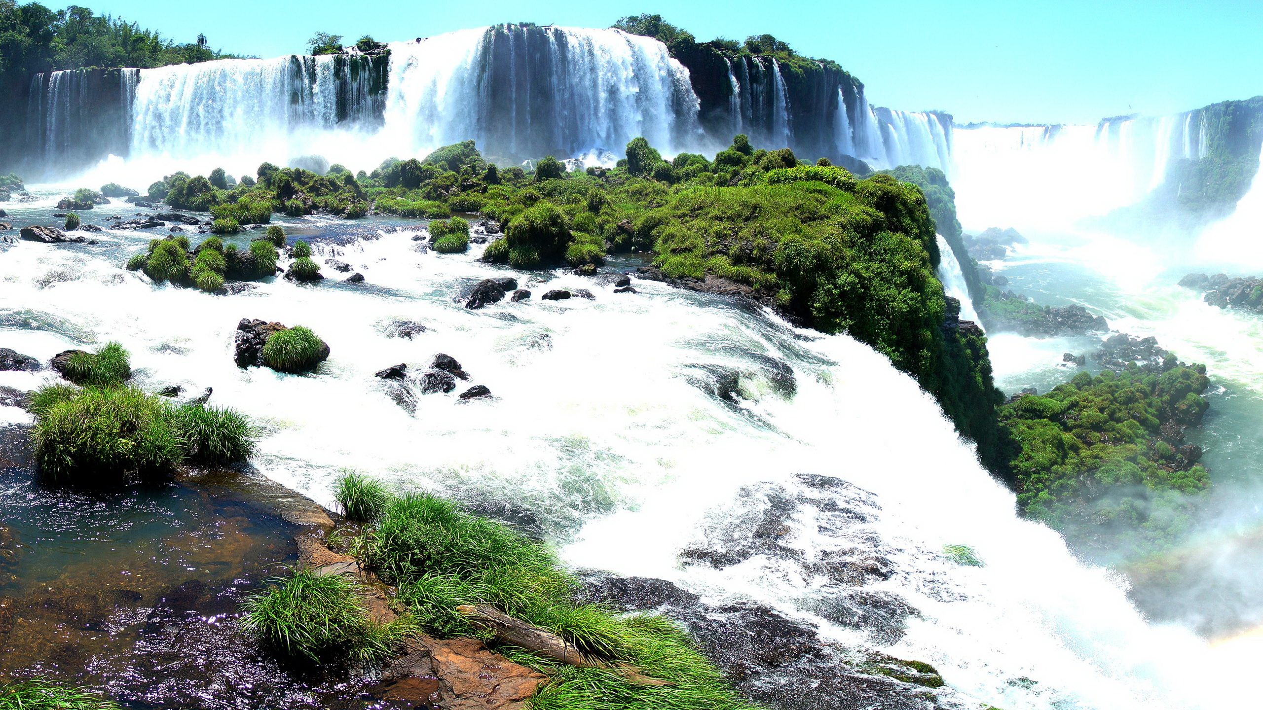 Iguazu Falls with lush green vegetation and rocky outcrops HD Wallpaper