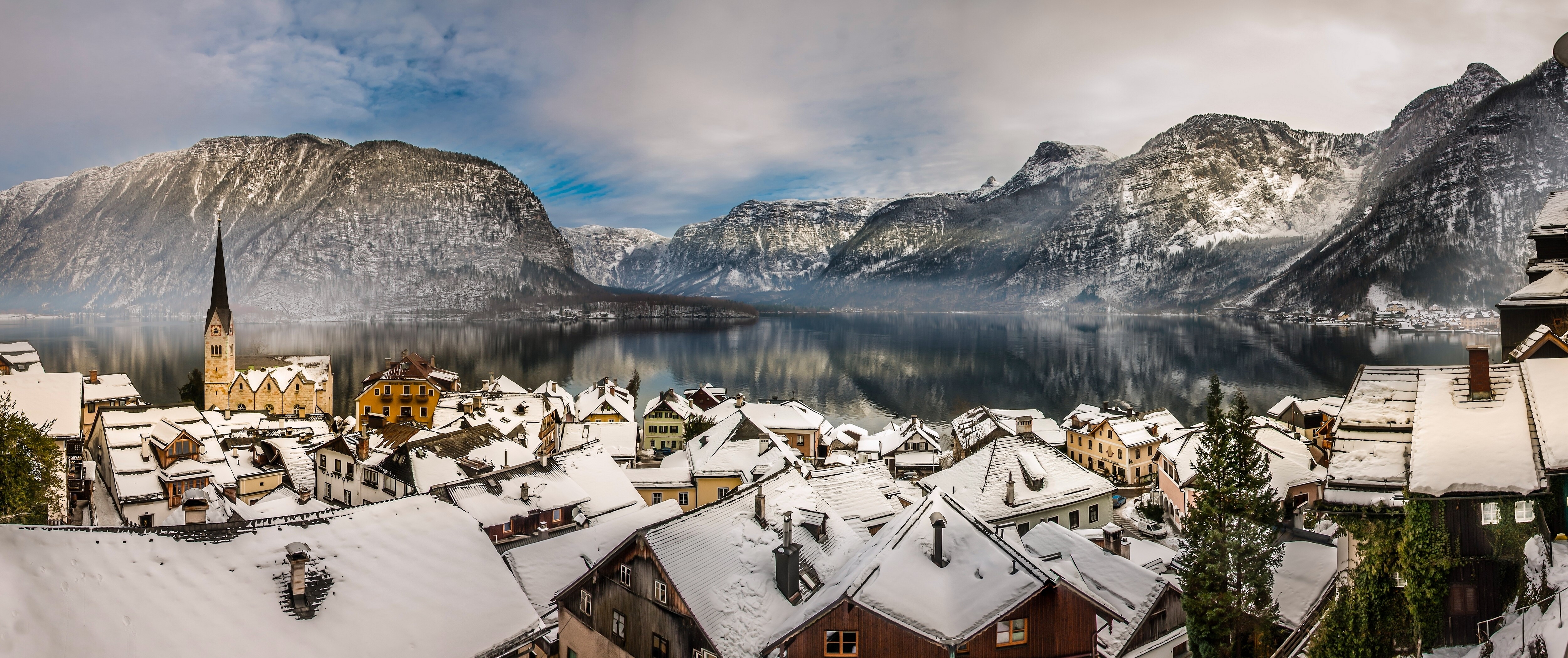 Hallstatt village with snow-covered roofs and mountains HD Wallpaper