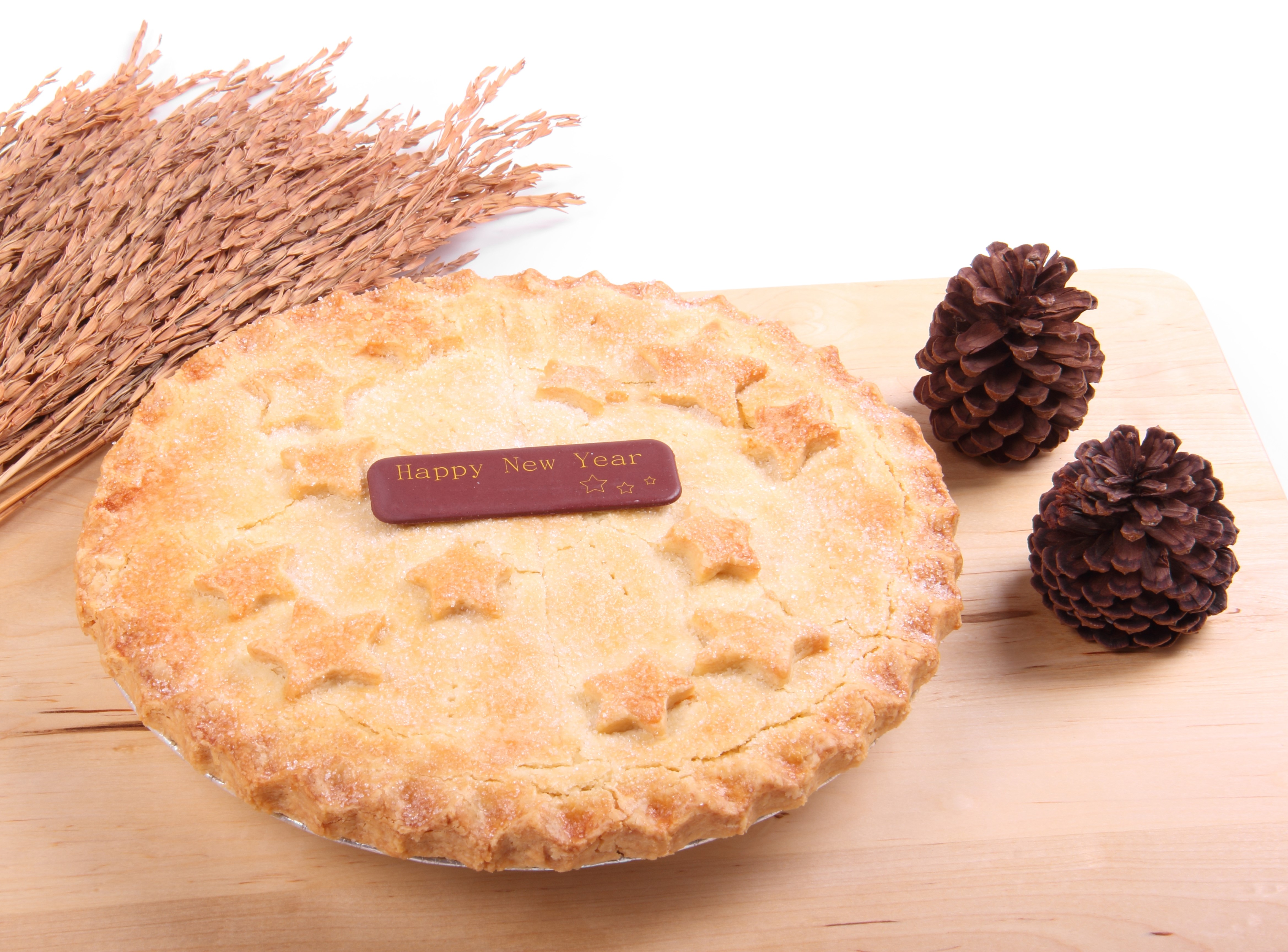 Pie with Happy New Year decoration and pine cones HD Wallpaper