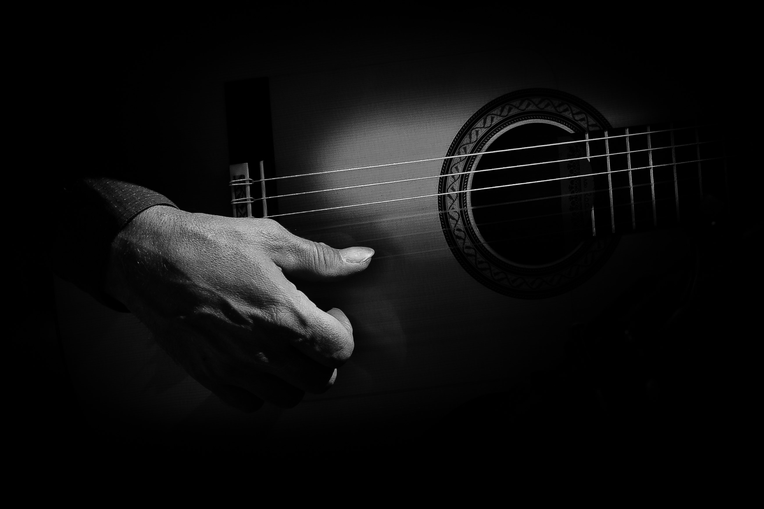 Close-up of a hand playing a guitar HD Wallpaper