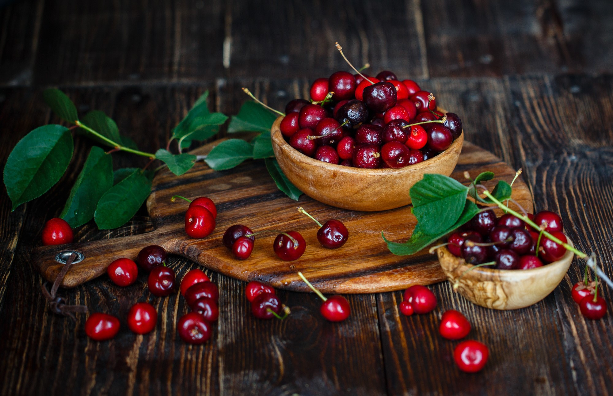 Cherries in wooden bowls on a wooden table HD Wallpaper