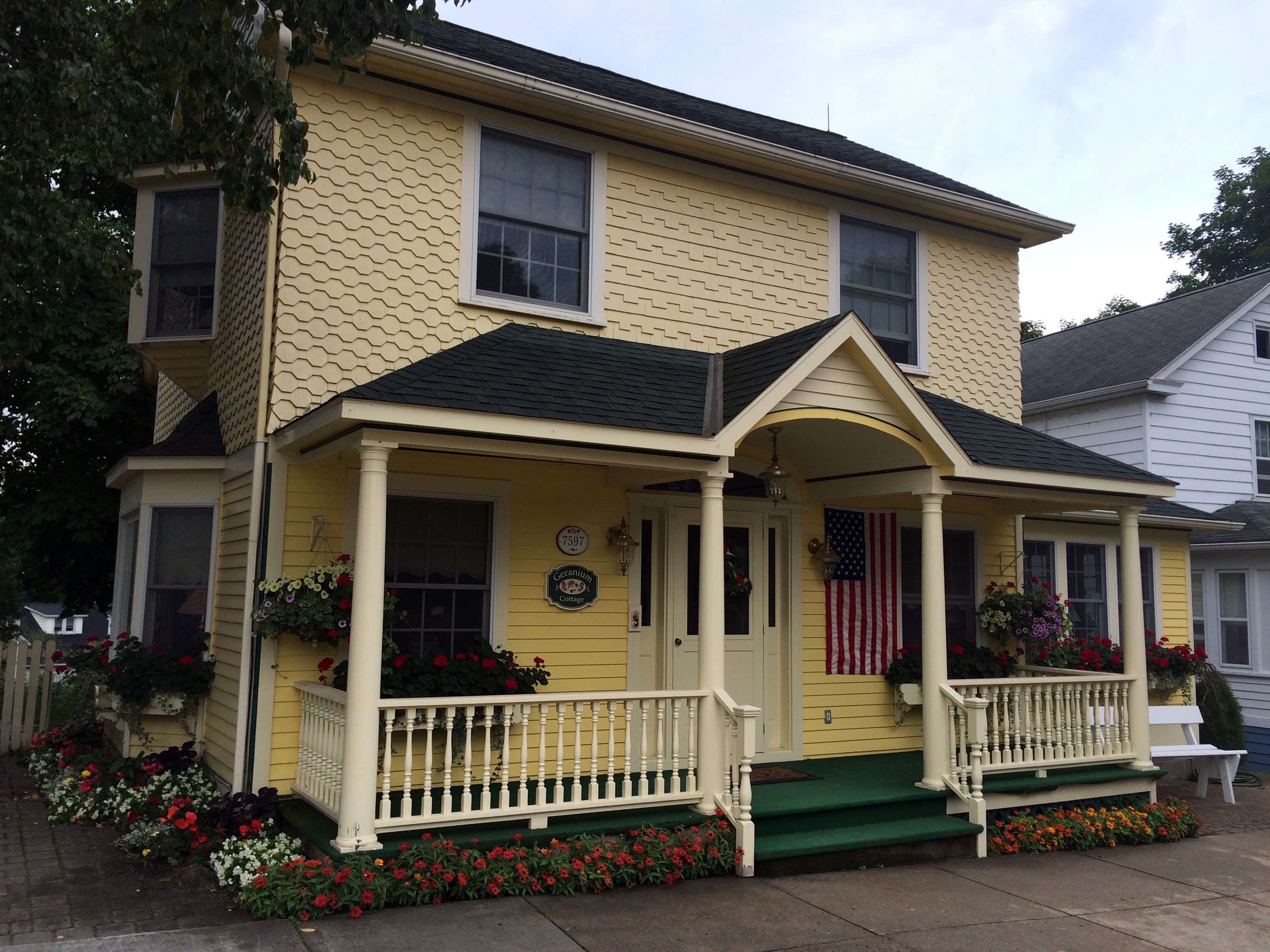 Yellow house with porch and American flag HD Wallpaper