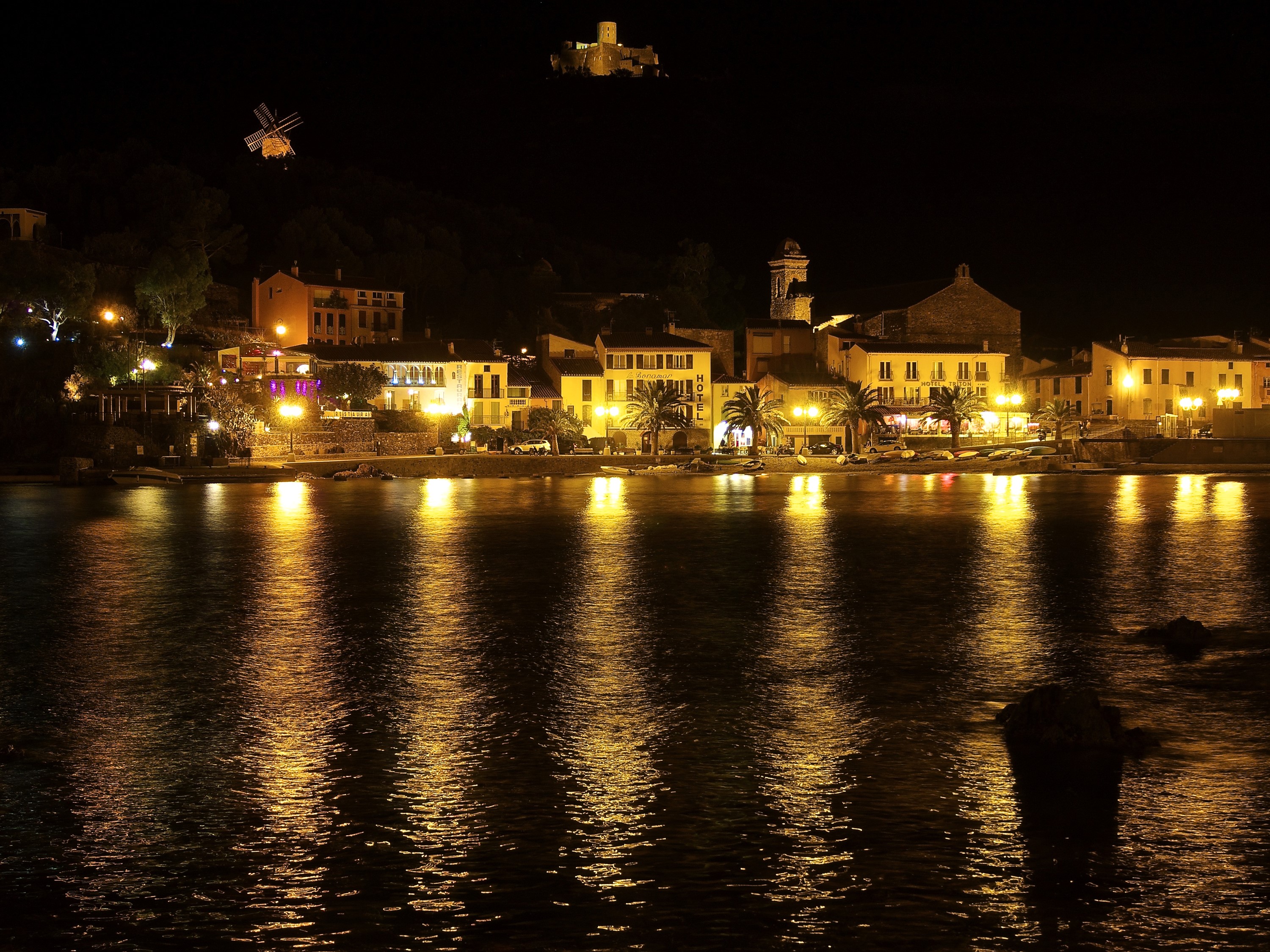 Collioure, France at night with reflections on the water HD Wallpaper