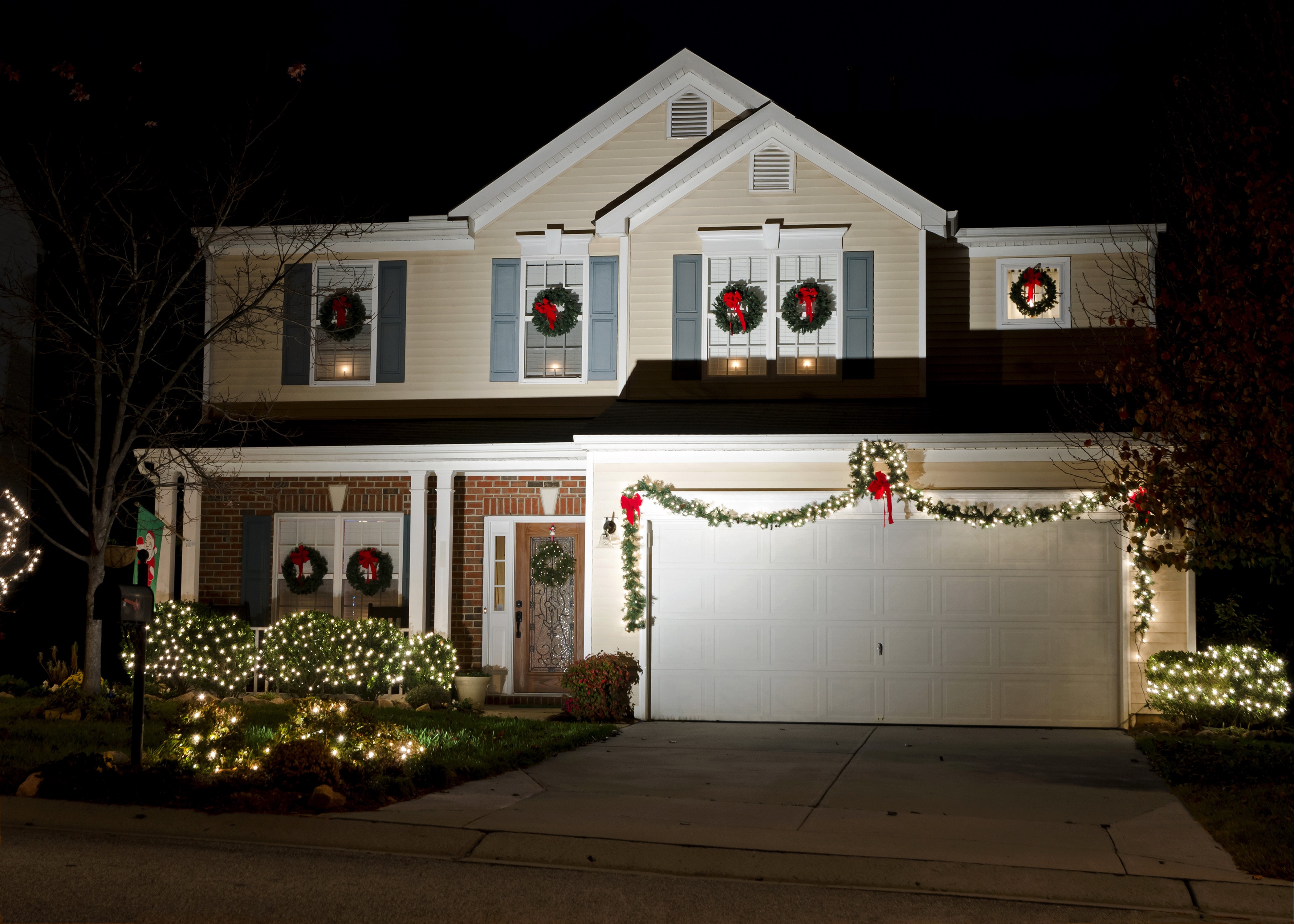House decorated with Christmas lights and wreaths at night HD Wallpaper