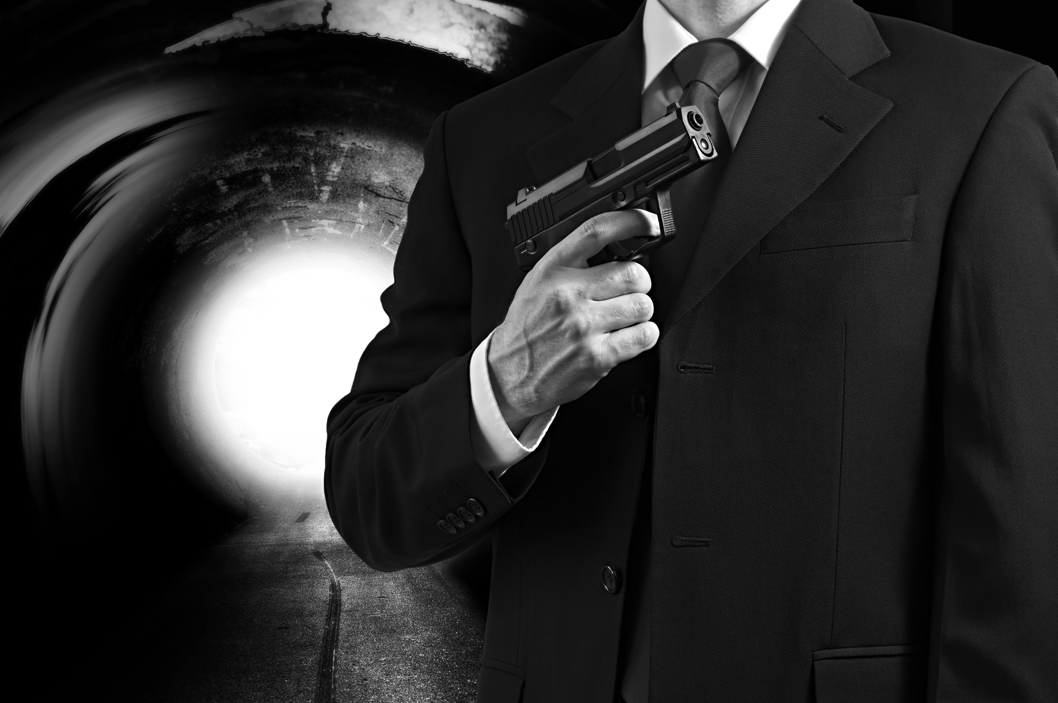 Man in Suit Holding a Pistol in a Tunnel HD Wallpaper