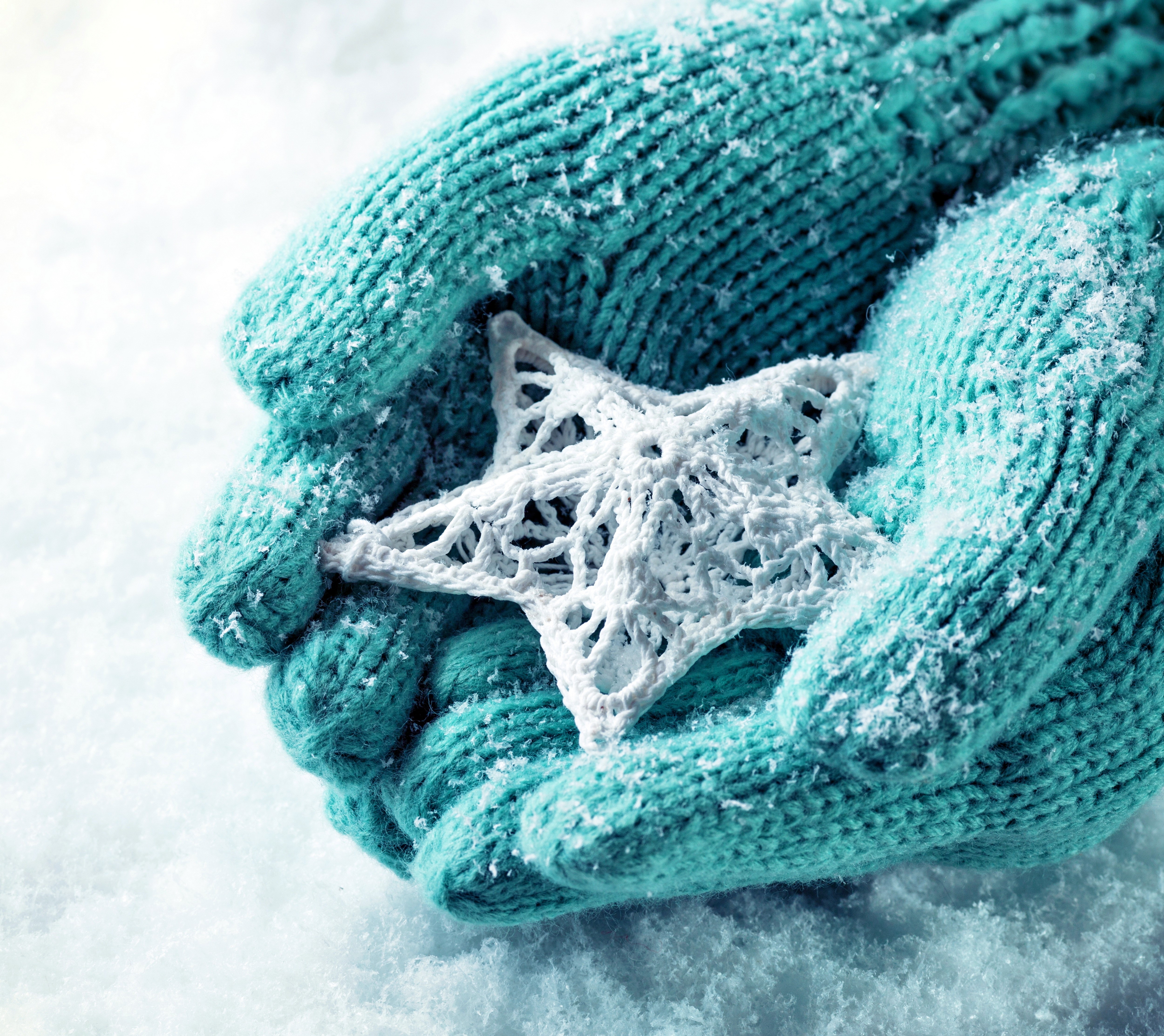 Hands in winter gloves holding a star ornament HD Wallpaper