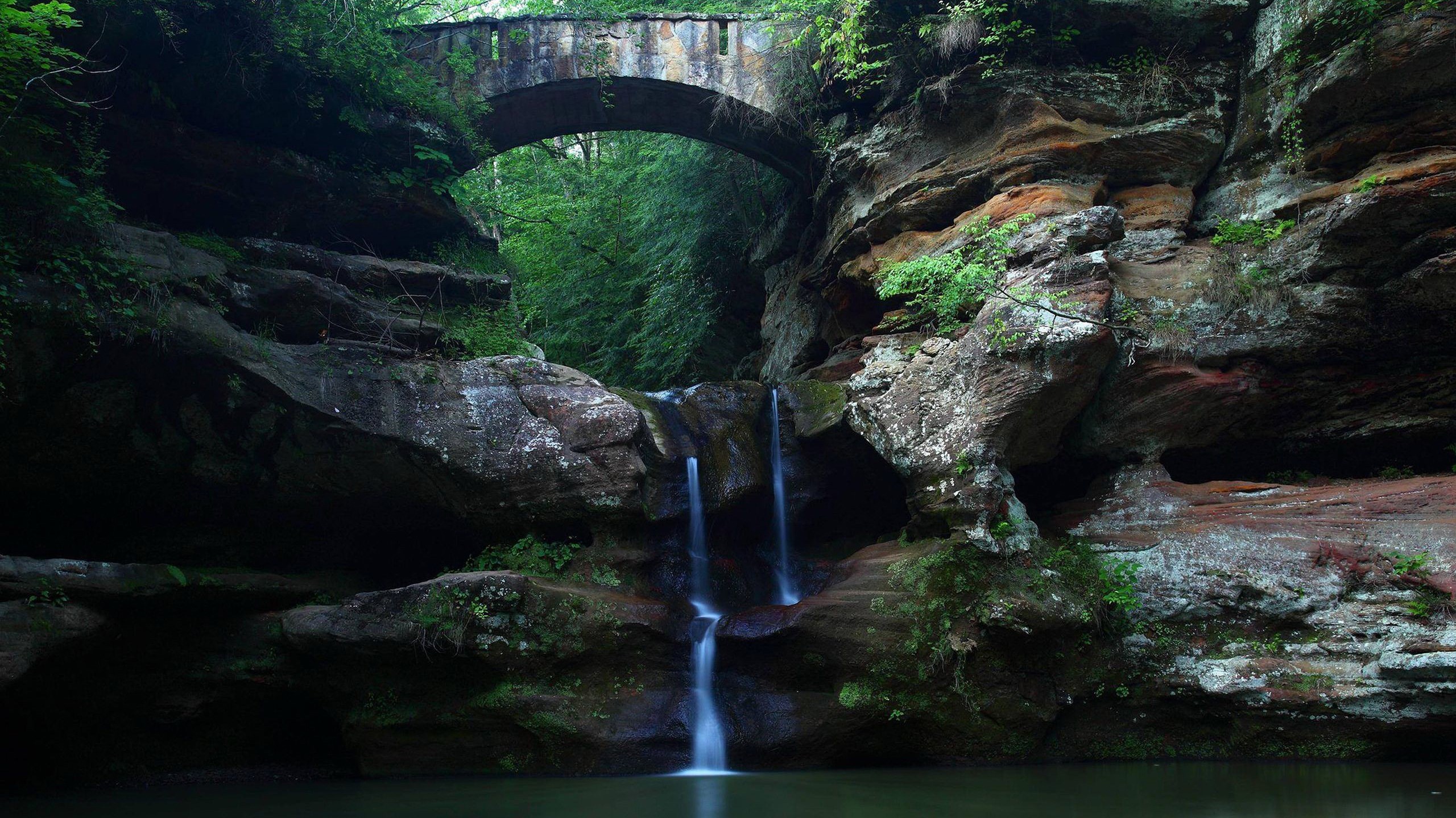 Stone bridge over a waterfall in a rocky gorge HD Wallpaper