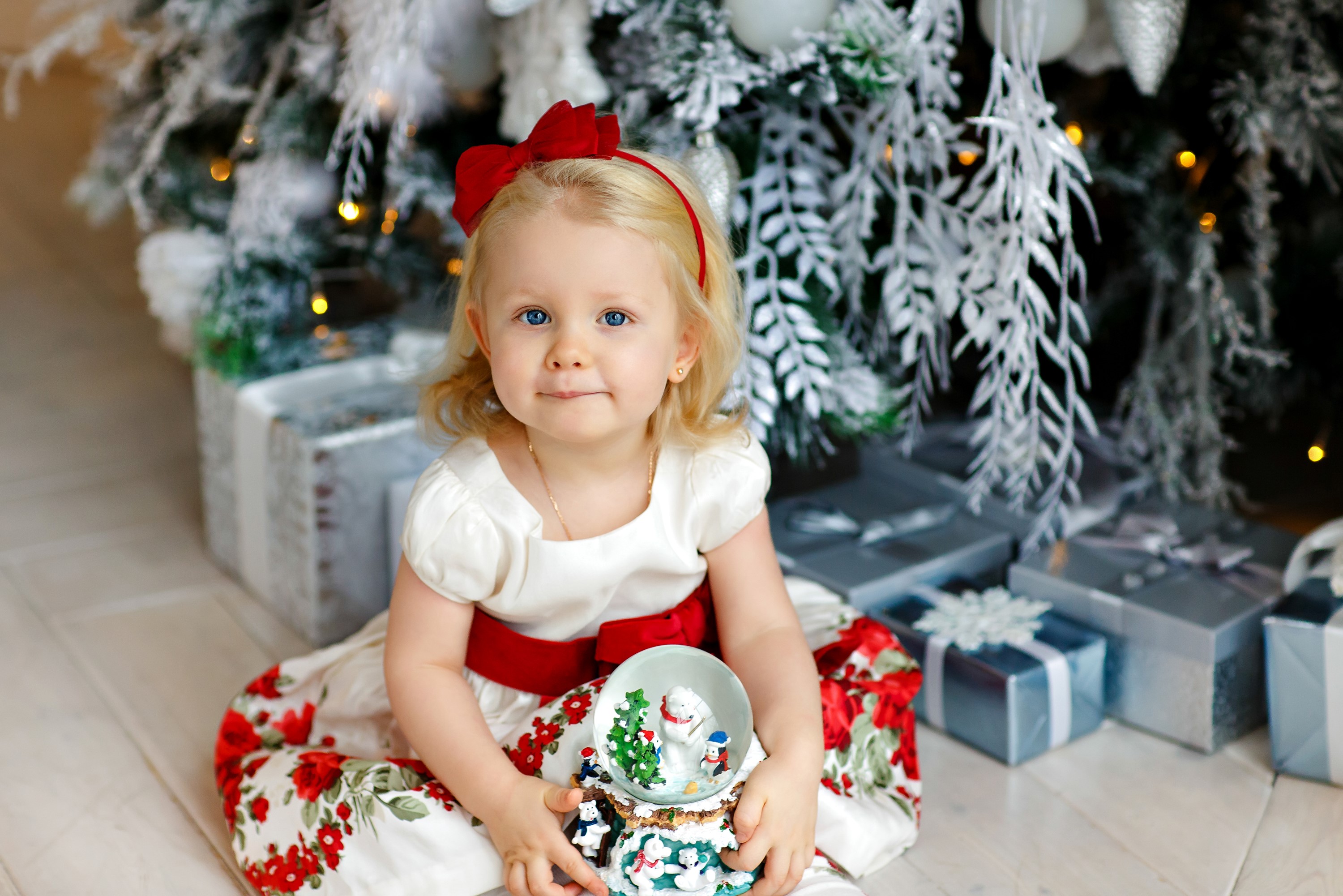 Little girl in a Christmas dress holding a snow globe HD Wallpaper