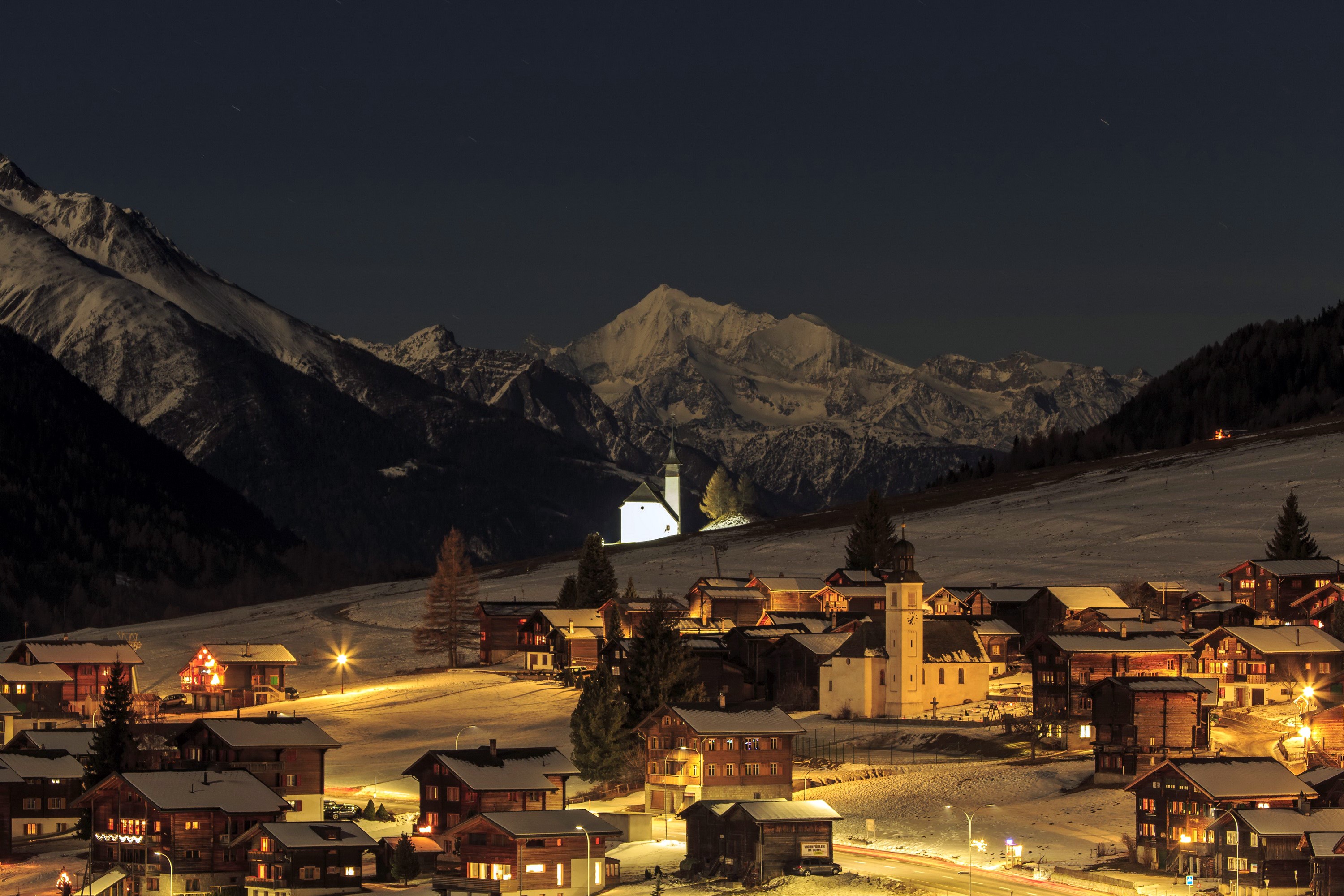 Snowy Swiss village at night with mountains HD Wallpaper