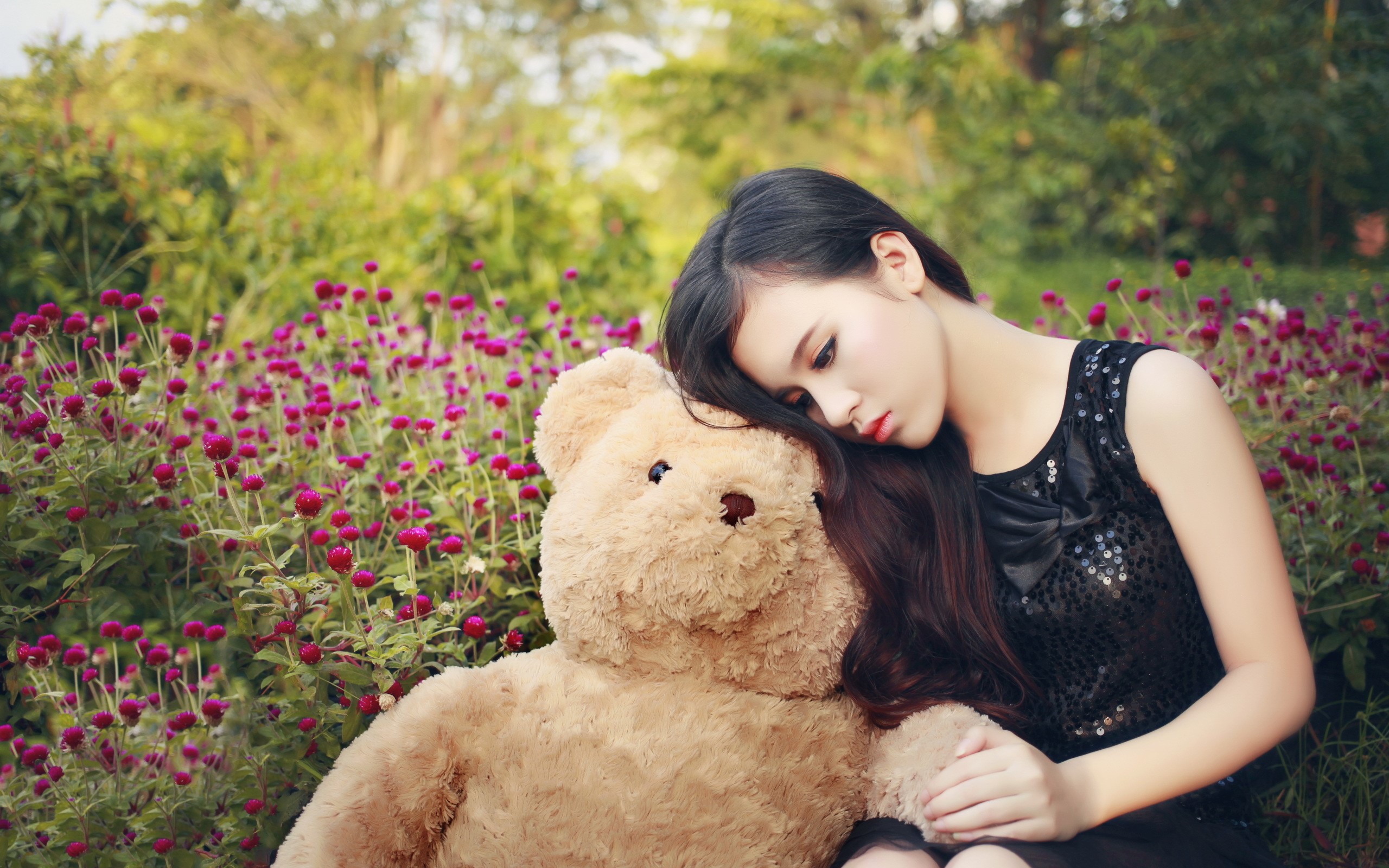 Young Asian woman with teddy bear in garden HD Wallpaper