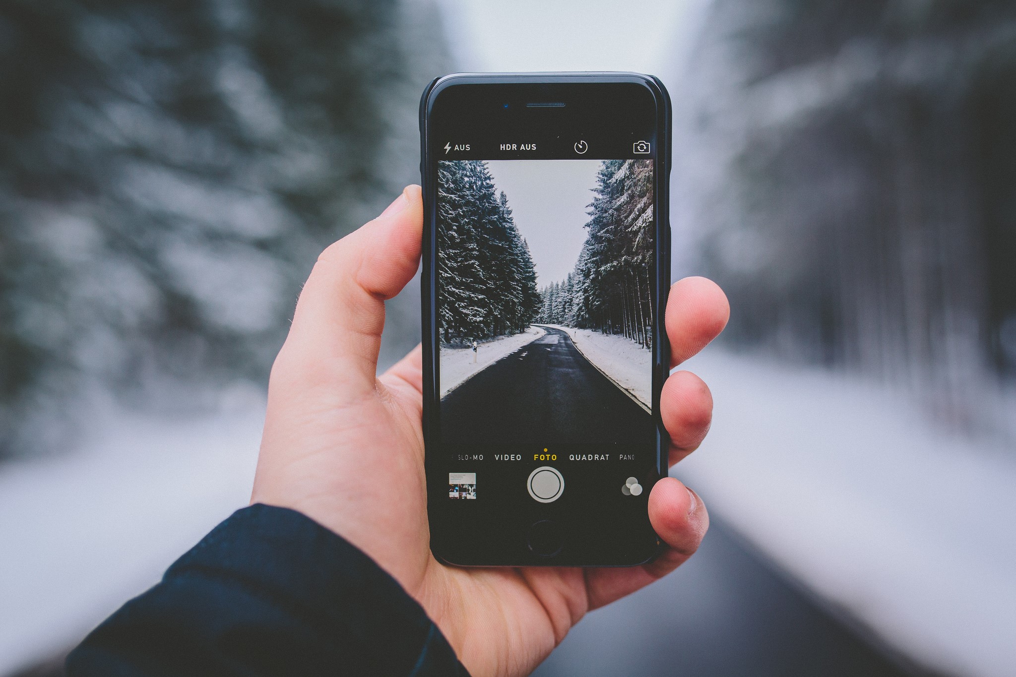 iPhone taking a photo of a snowy road HD Wallpaper