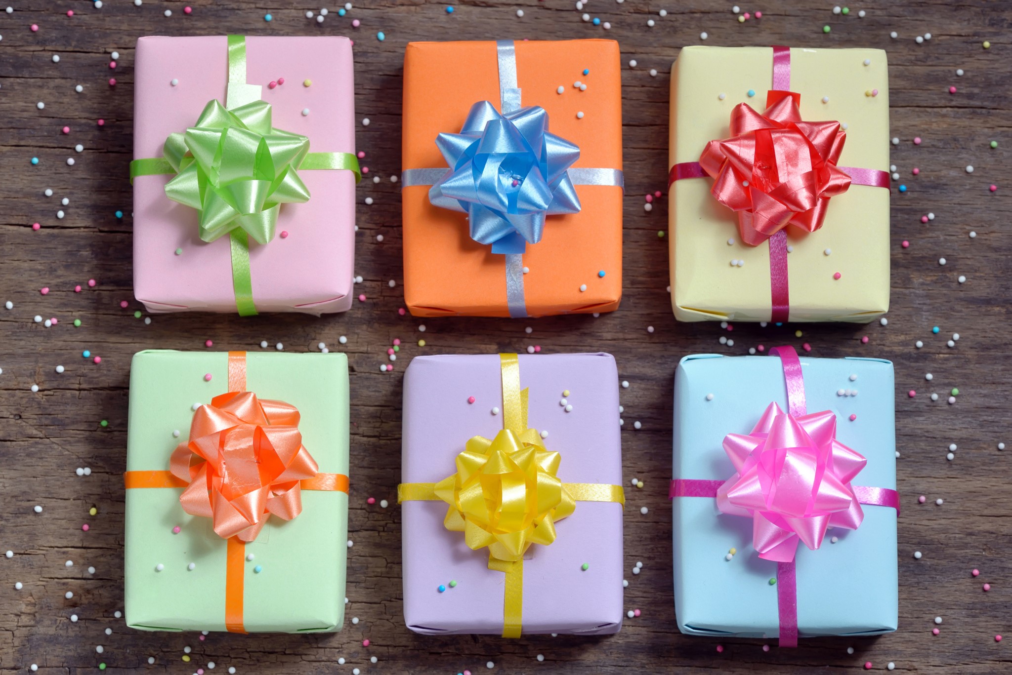Six colorful gift boxes with bows on wooden background HD Wallpaper