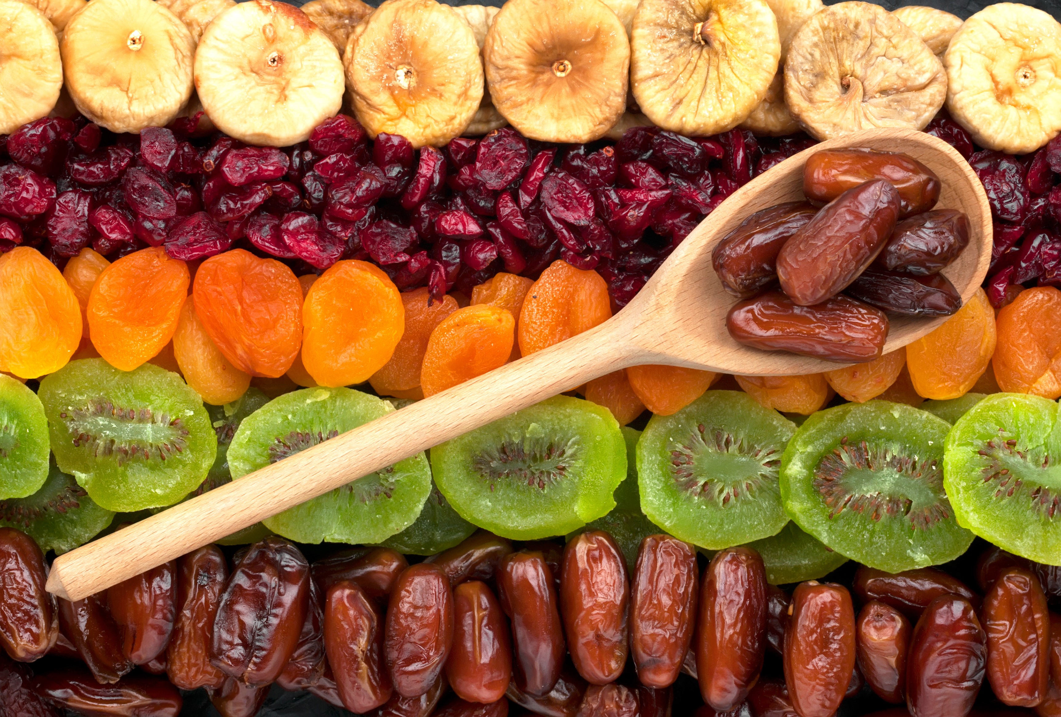 Assortment of dried fruits including figs, cranberries, apricots, kiwi, and dates HD Wallpaper