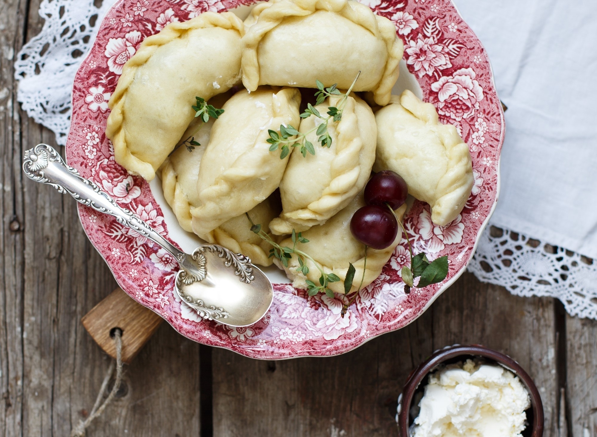 Pierogi with cherries and thyme on a plate HD Wallpaper