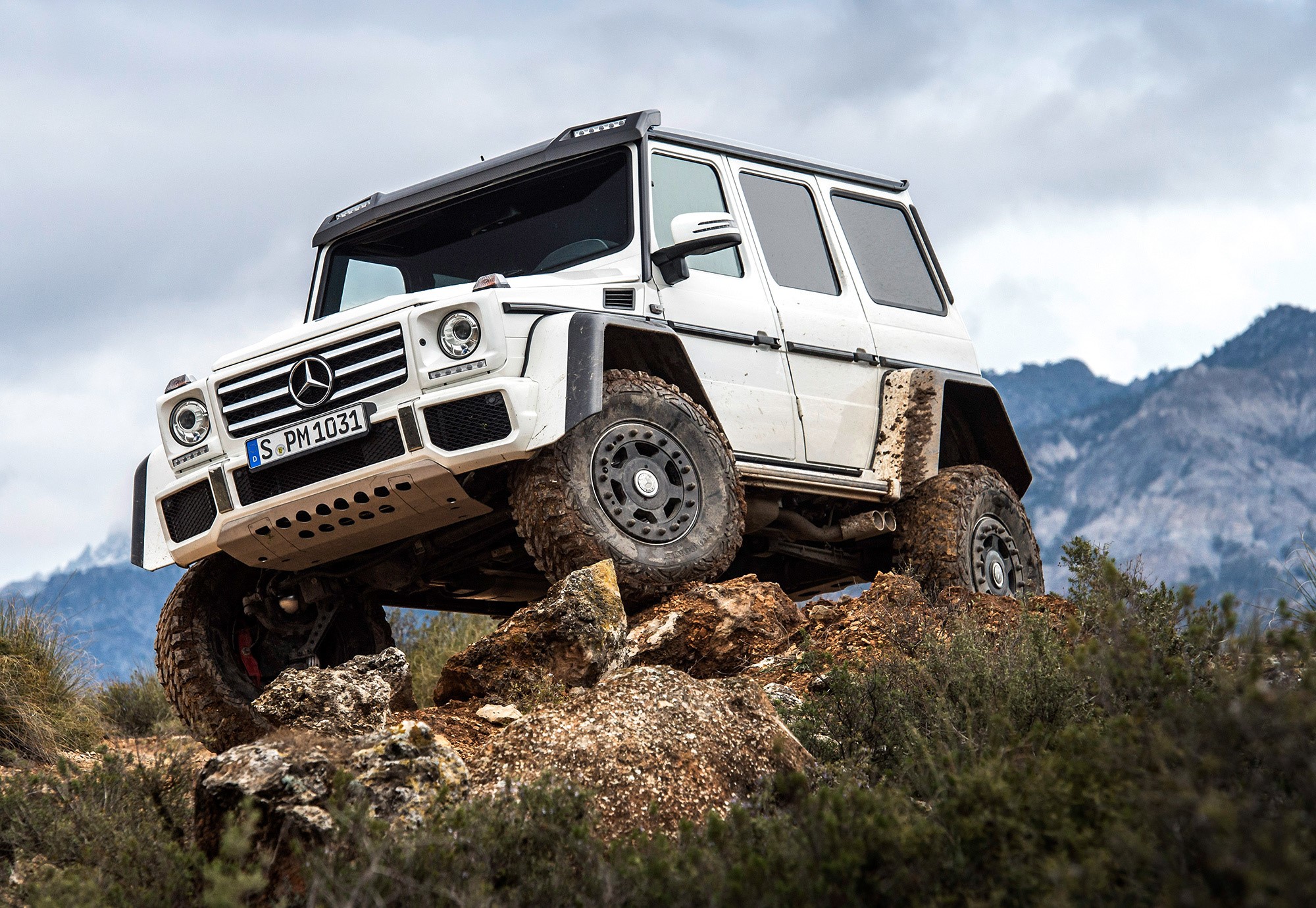 White Mercedes-Benz G500 4x4 off-roading on rocky terrain HD Wallpaper