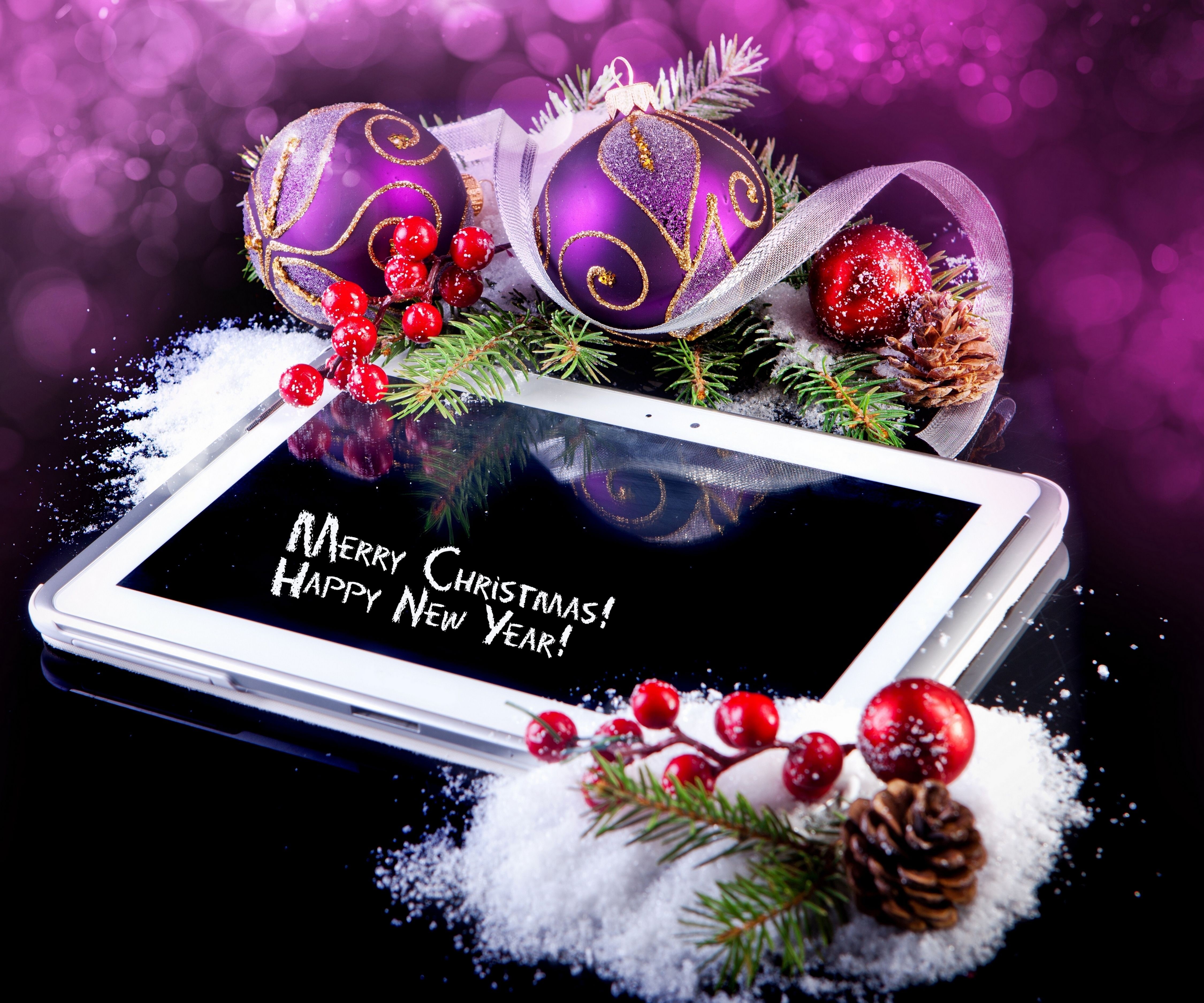 Christmas decorations on a tablet displaying Merry Christmas HD Wallpaper