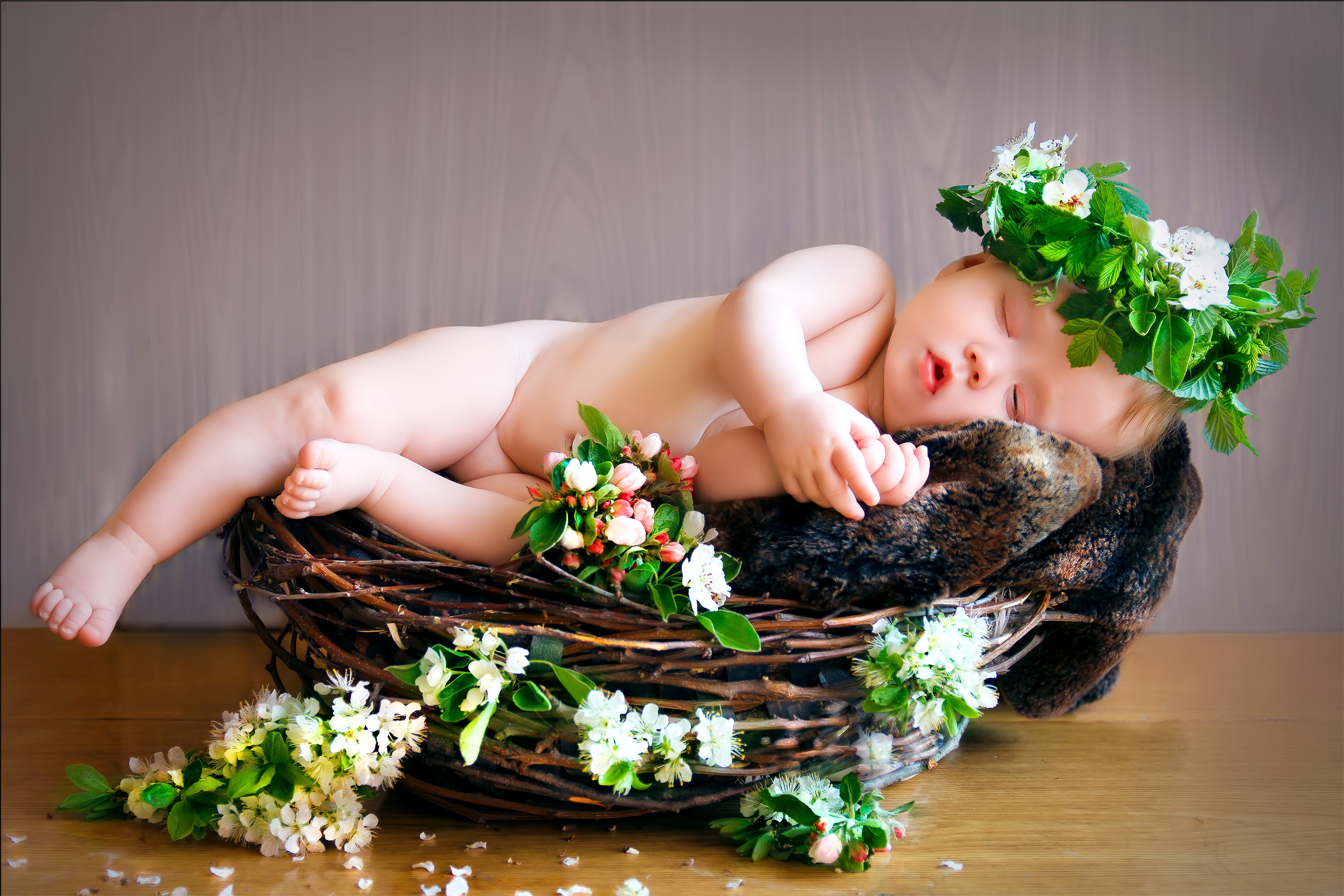 Baby sleeping in a wicker basket with flowers HD Wallpaper