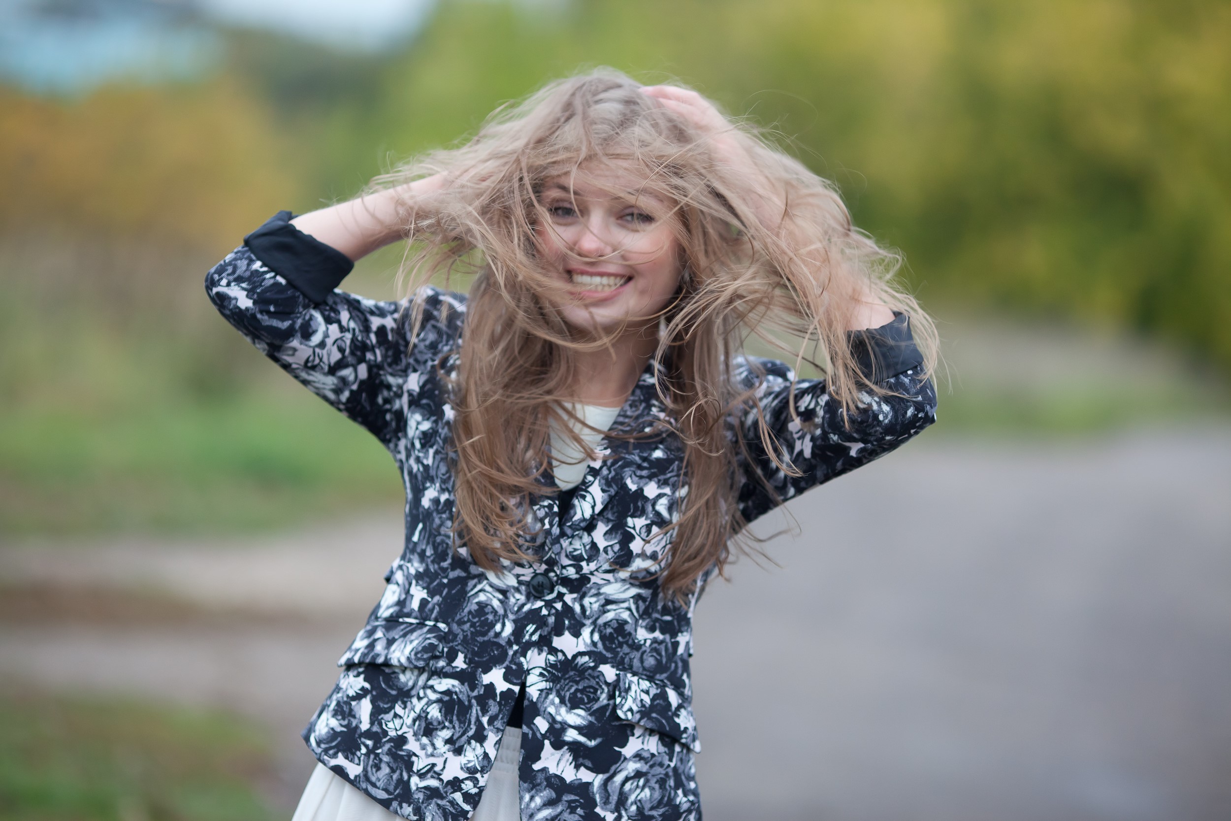 Woman with windblown hair and floral jacket HD Wallpaper