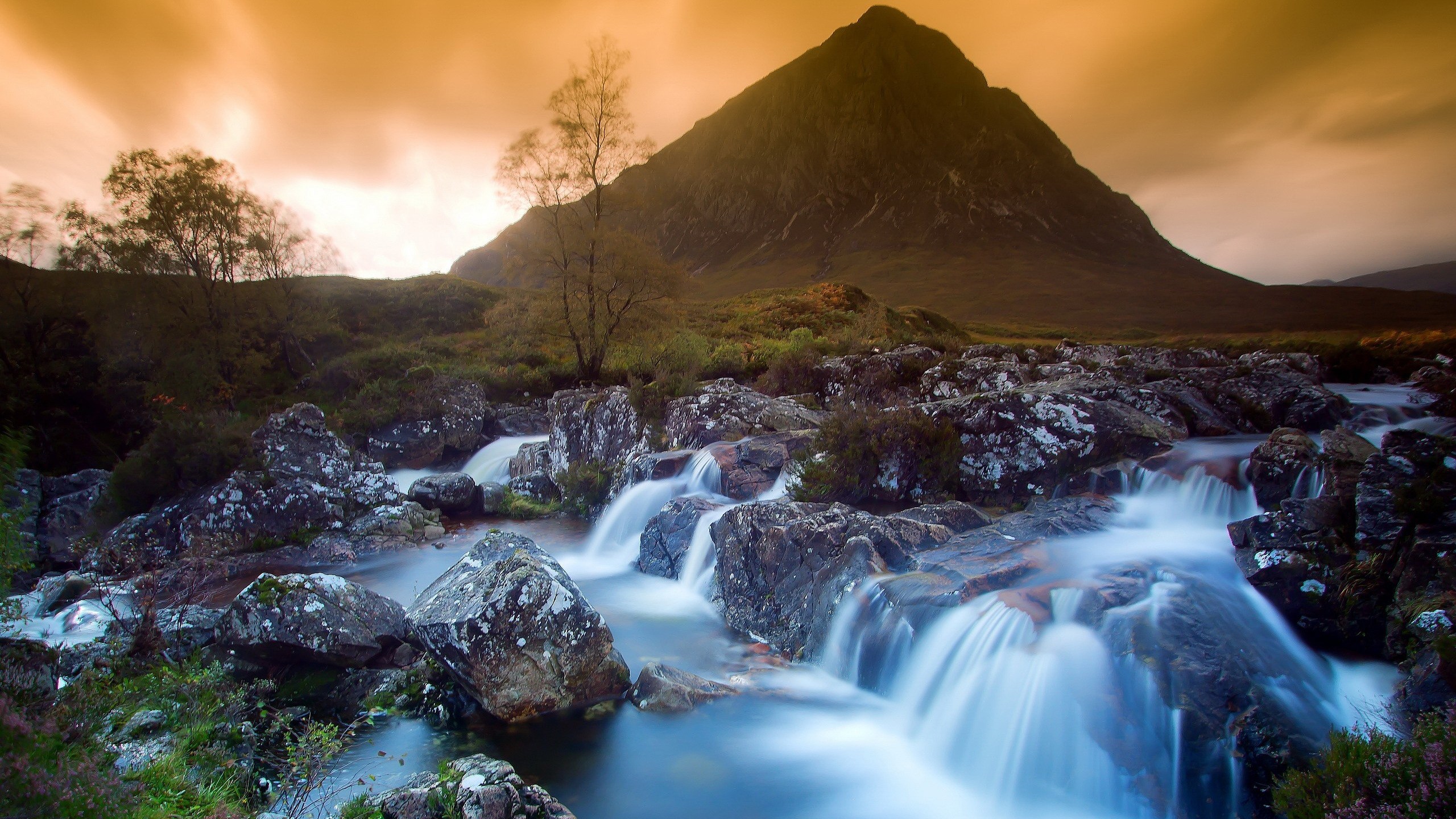 Mountain stream flowing over rocks with a mountain in the background HD Wallpaper
