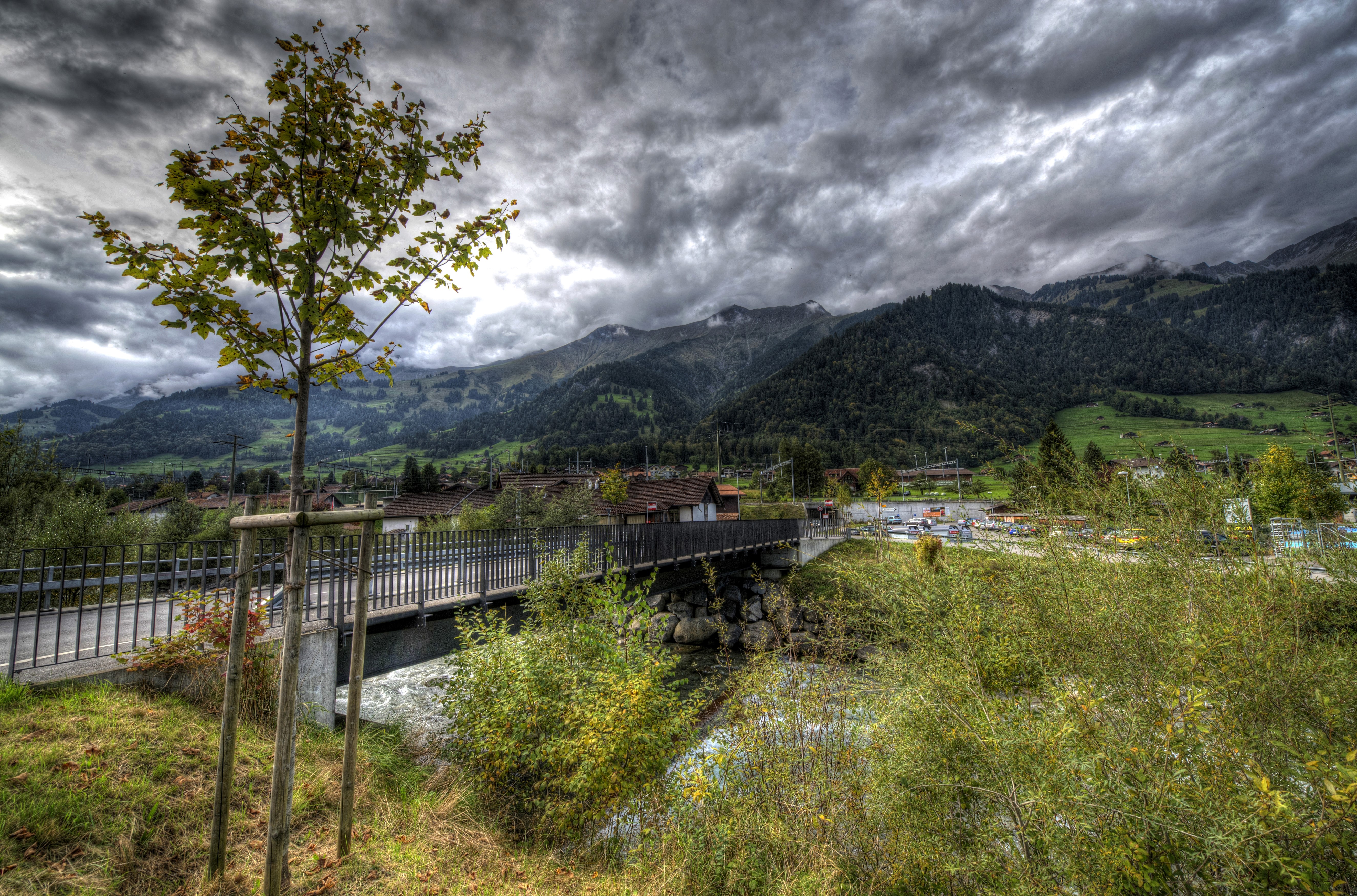 Bridge over river in Frutigen, Switzerland with mountains HD Wallpaper