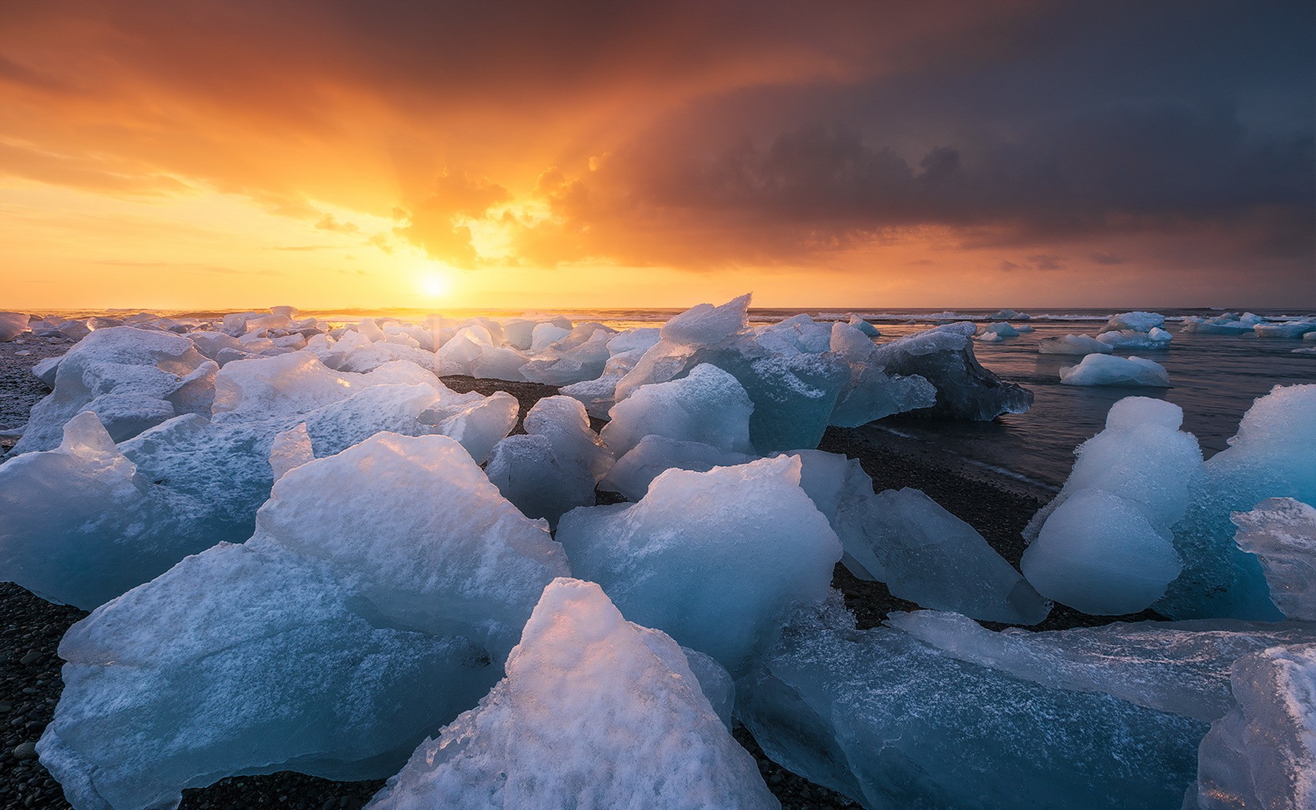 Ice chunks on a beach at sunset HD Wallpaper