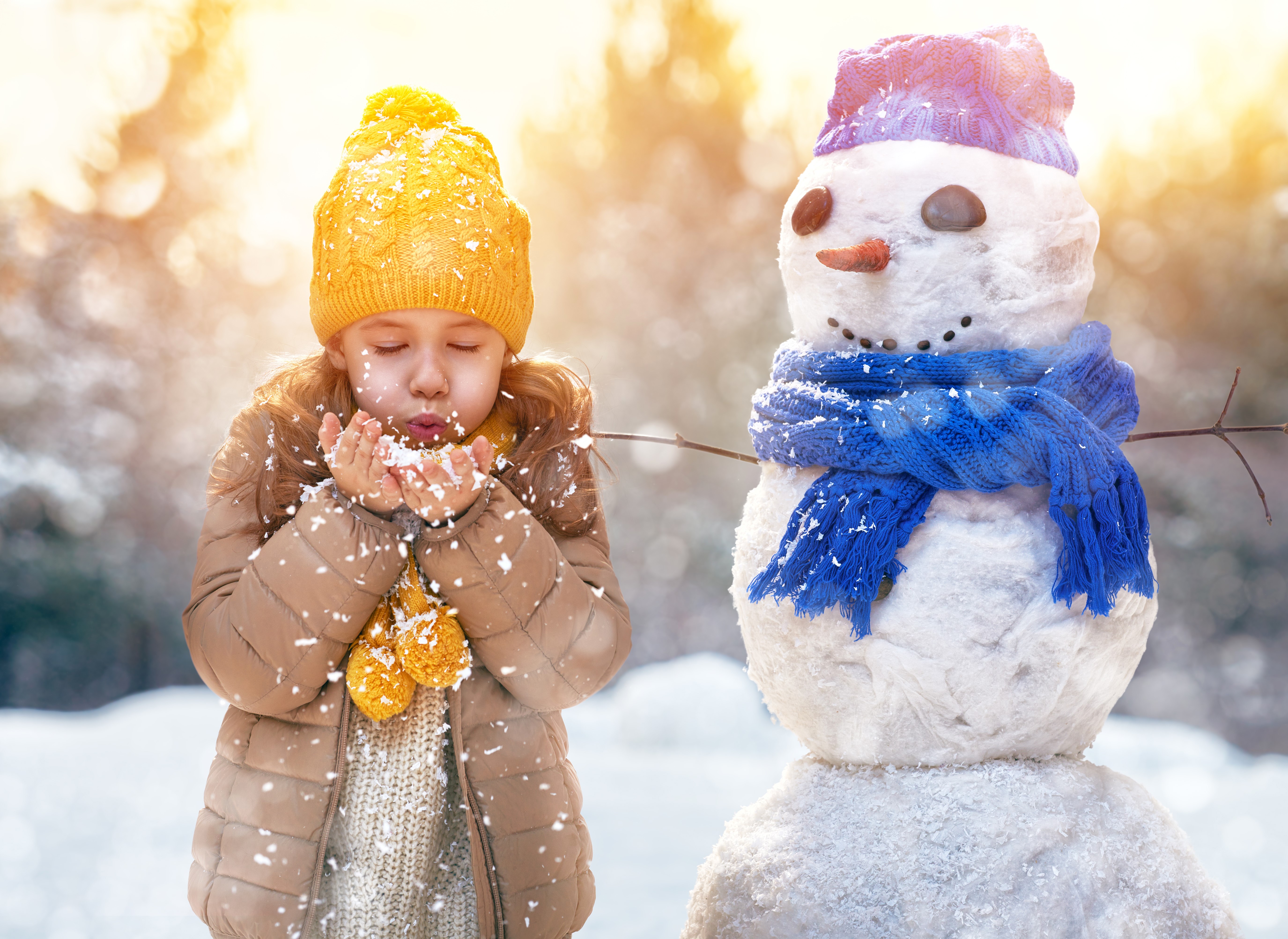 Girl blowing snow near a snowman HD Wallpaper