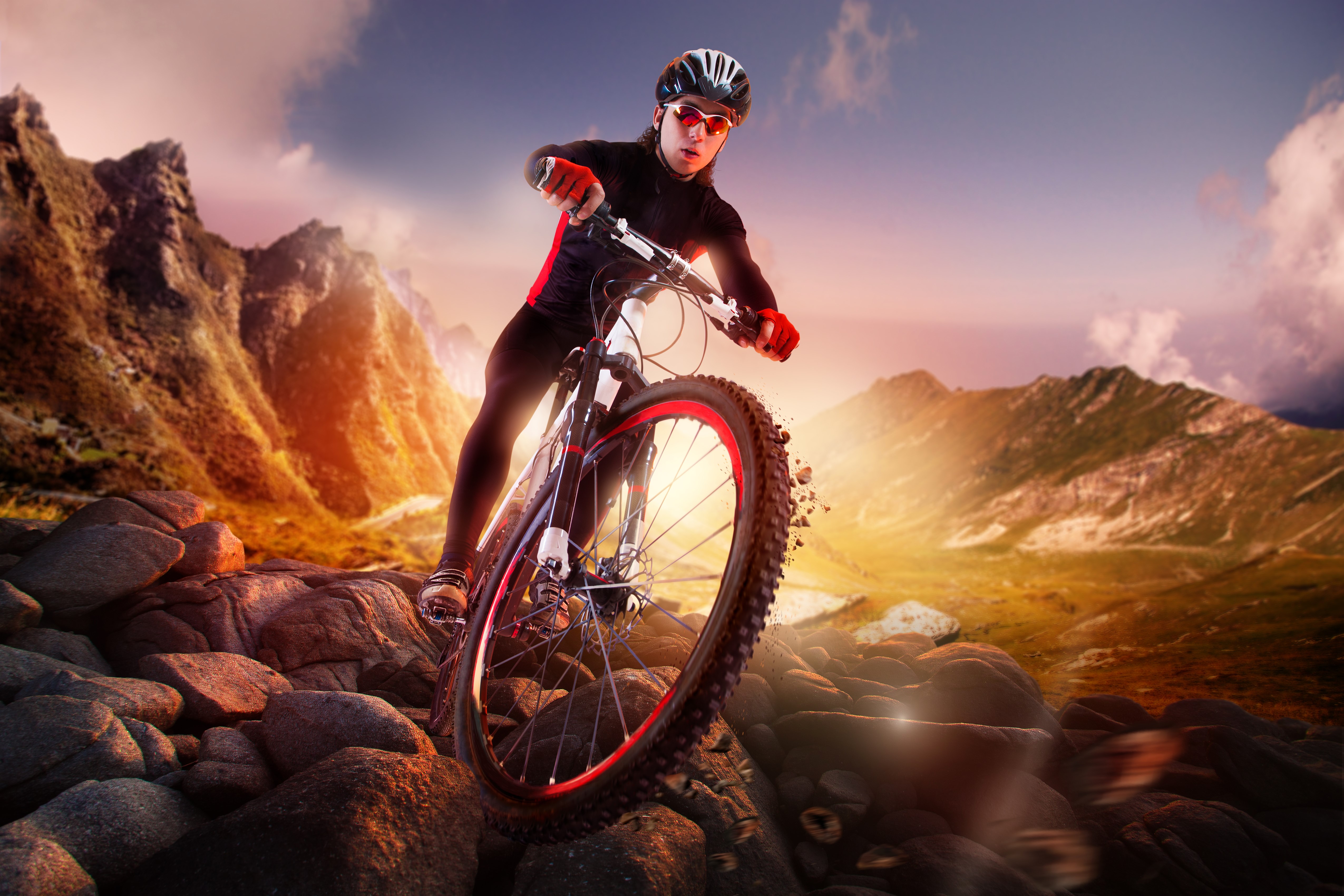 Mountain biker on rocky terrain at sunset HD Wallpaper