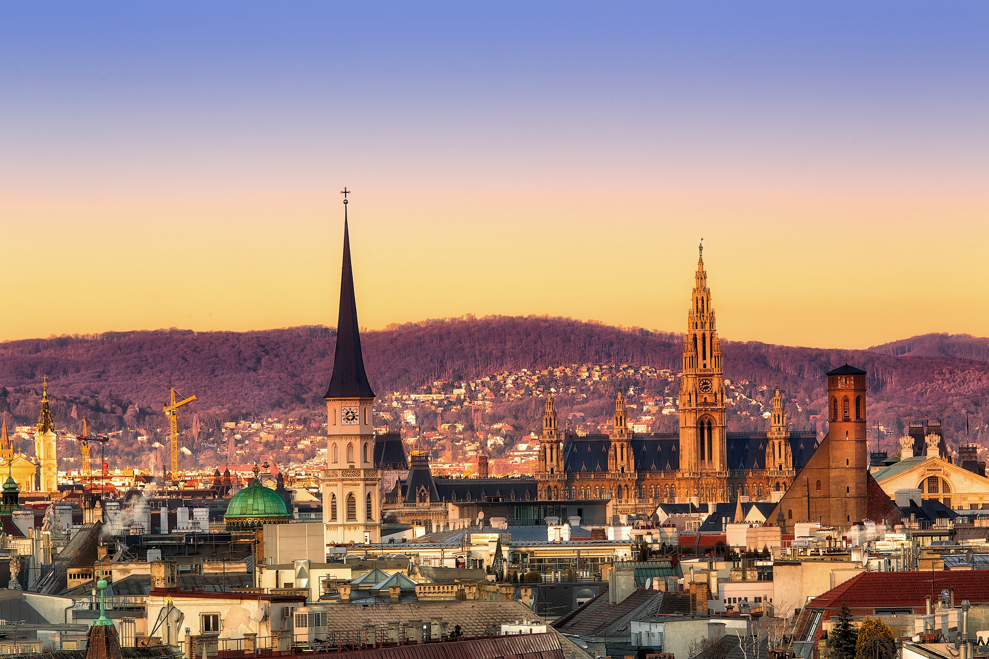 Vienna cityscape with churches and mountains at sunset HD Wallpaper