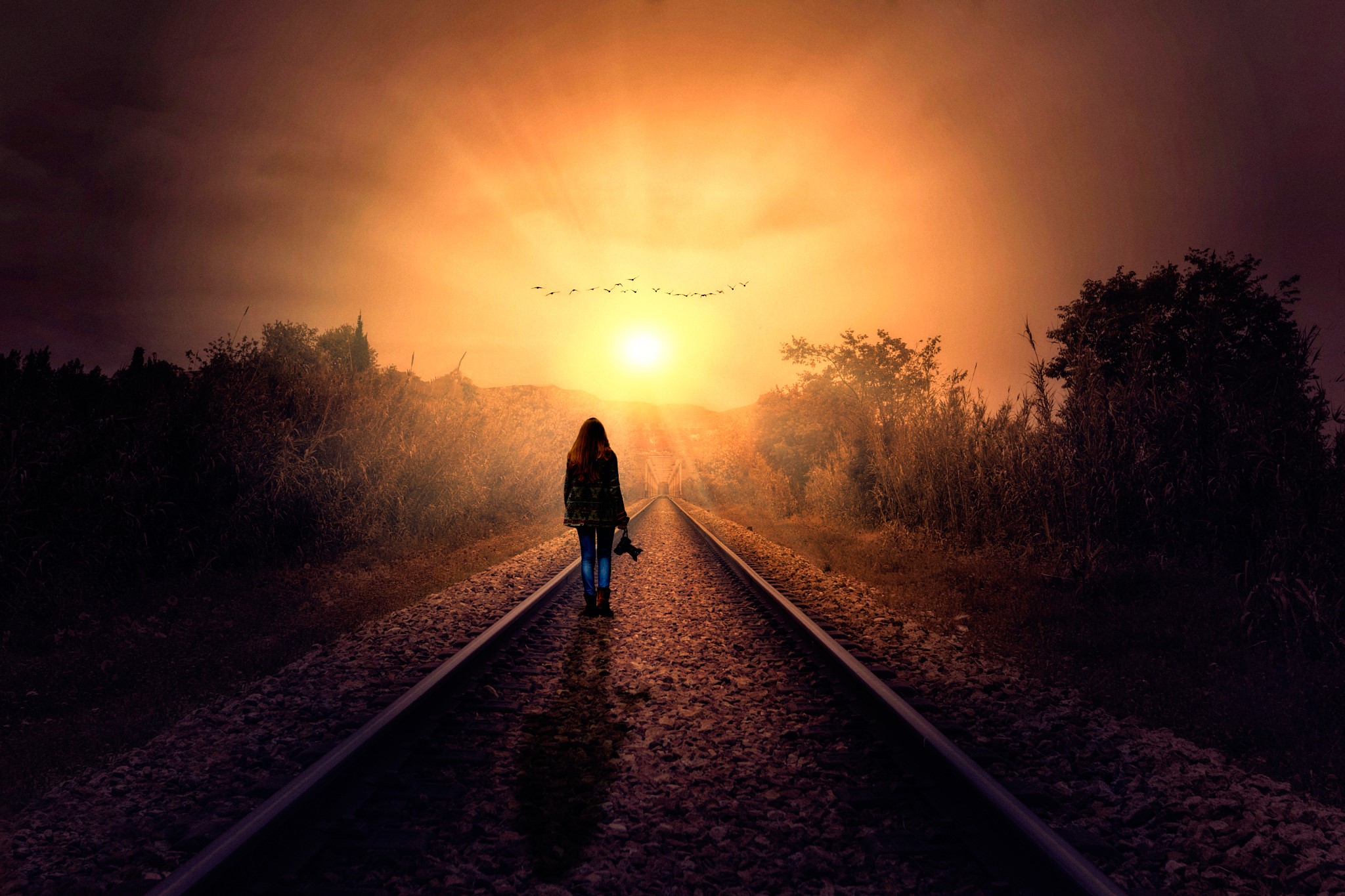 Woman walking on railroad tracks at sunset HD Wallpaper