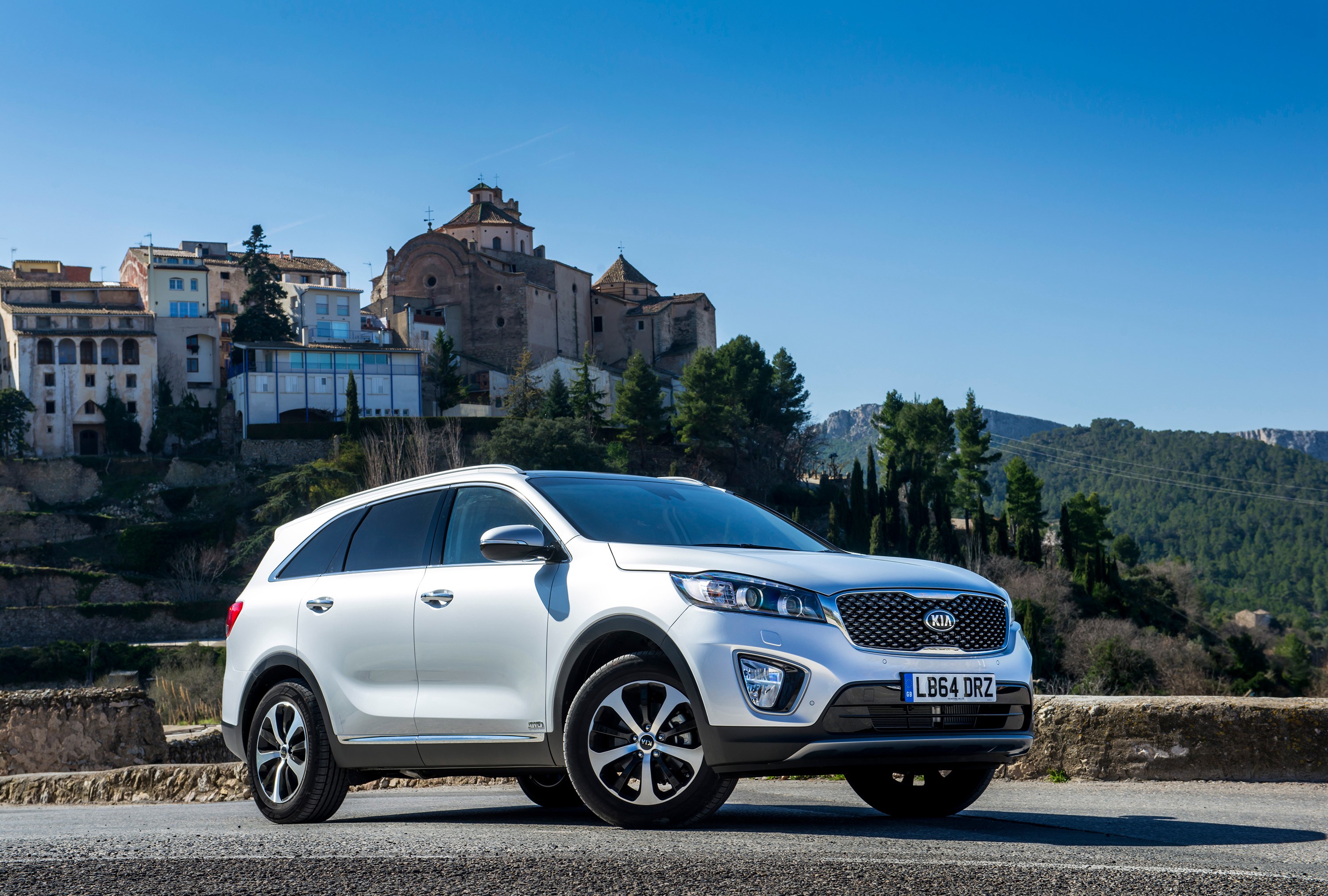 White Kia Sorento parked in front of a European village HD Wallpaper