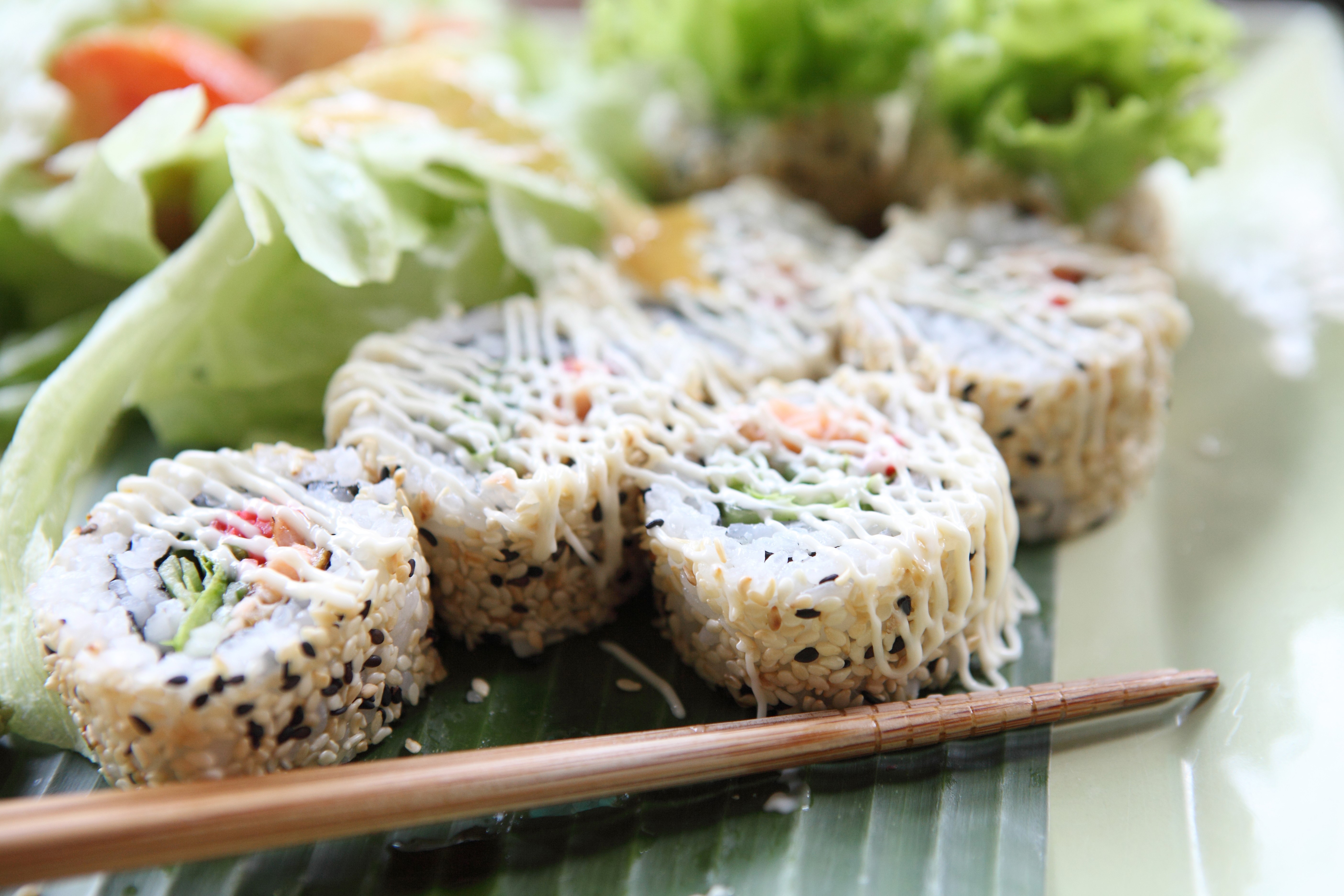 Sushi rolls with salad and chopsticks HD Wallpaper