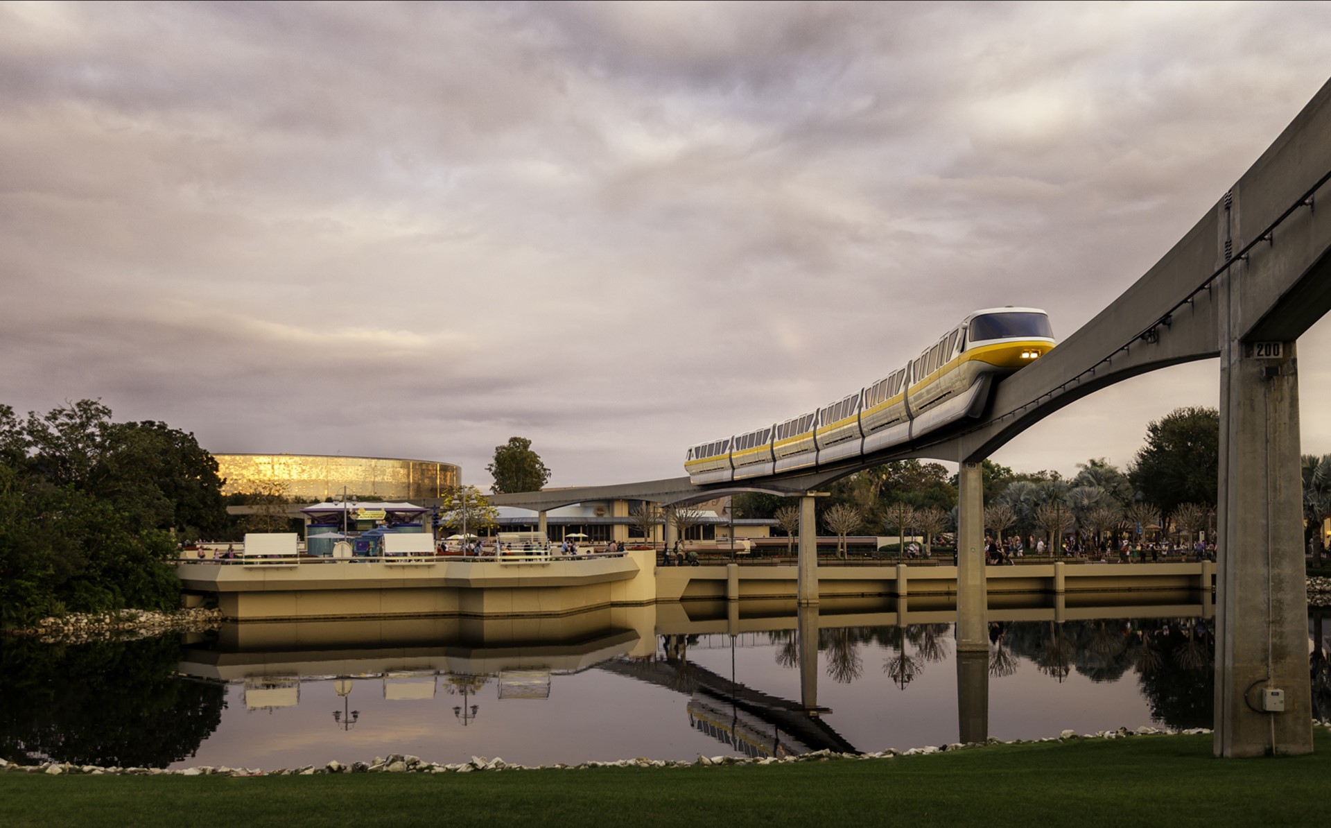 Monorail train on elevated track over water with Epcot in background HD Wallpaper