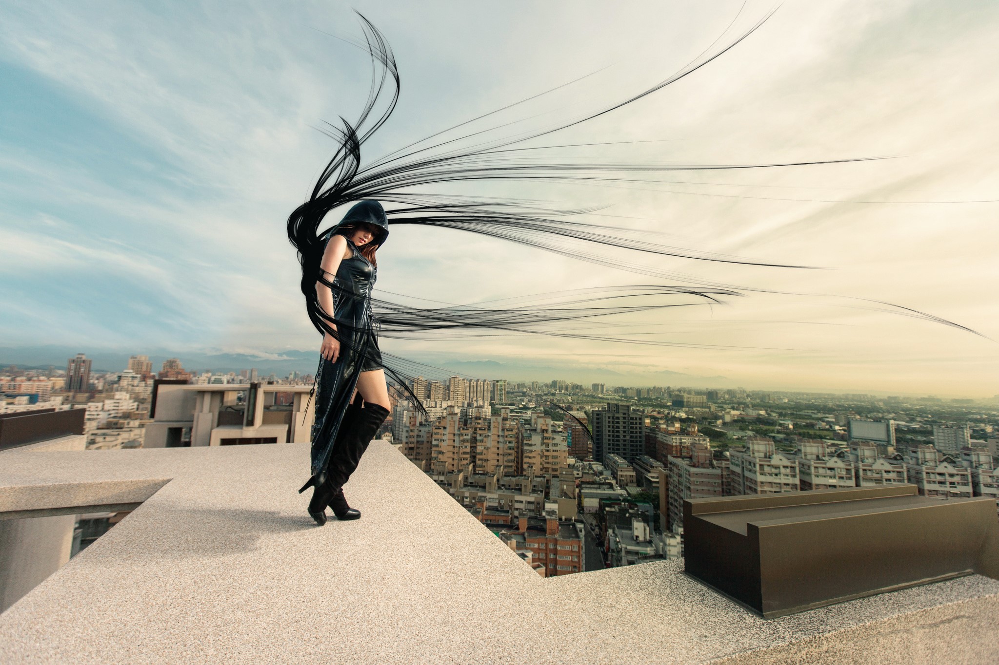 Woman in black dress with dark hair on a rooftop overlooking city HD Wallpaper