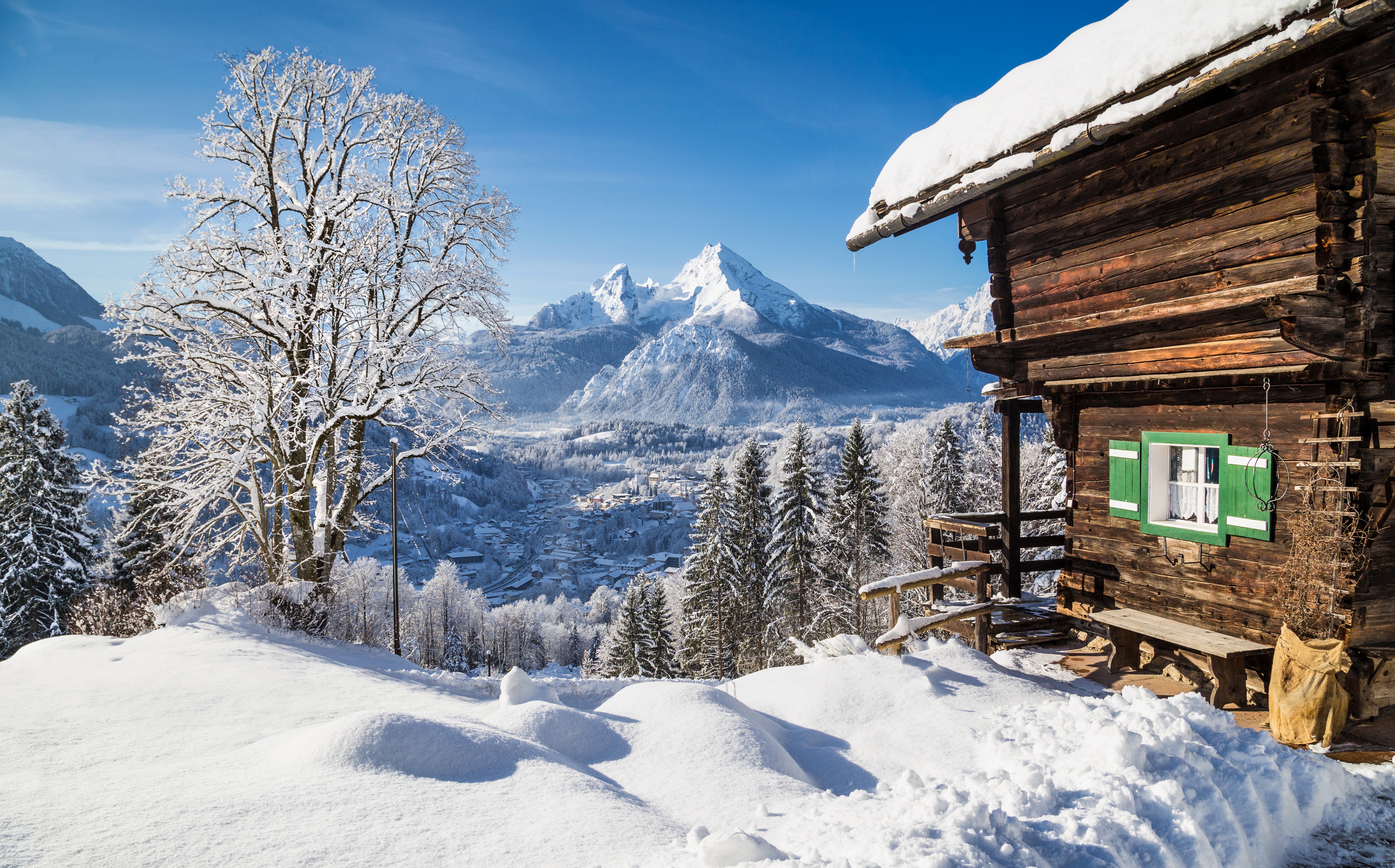 Winter scene with snow-covered mountains and a wooden cabin HD Wallpaper