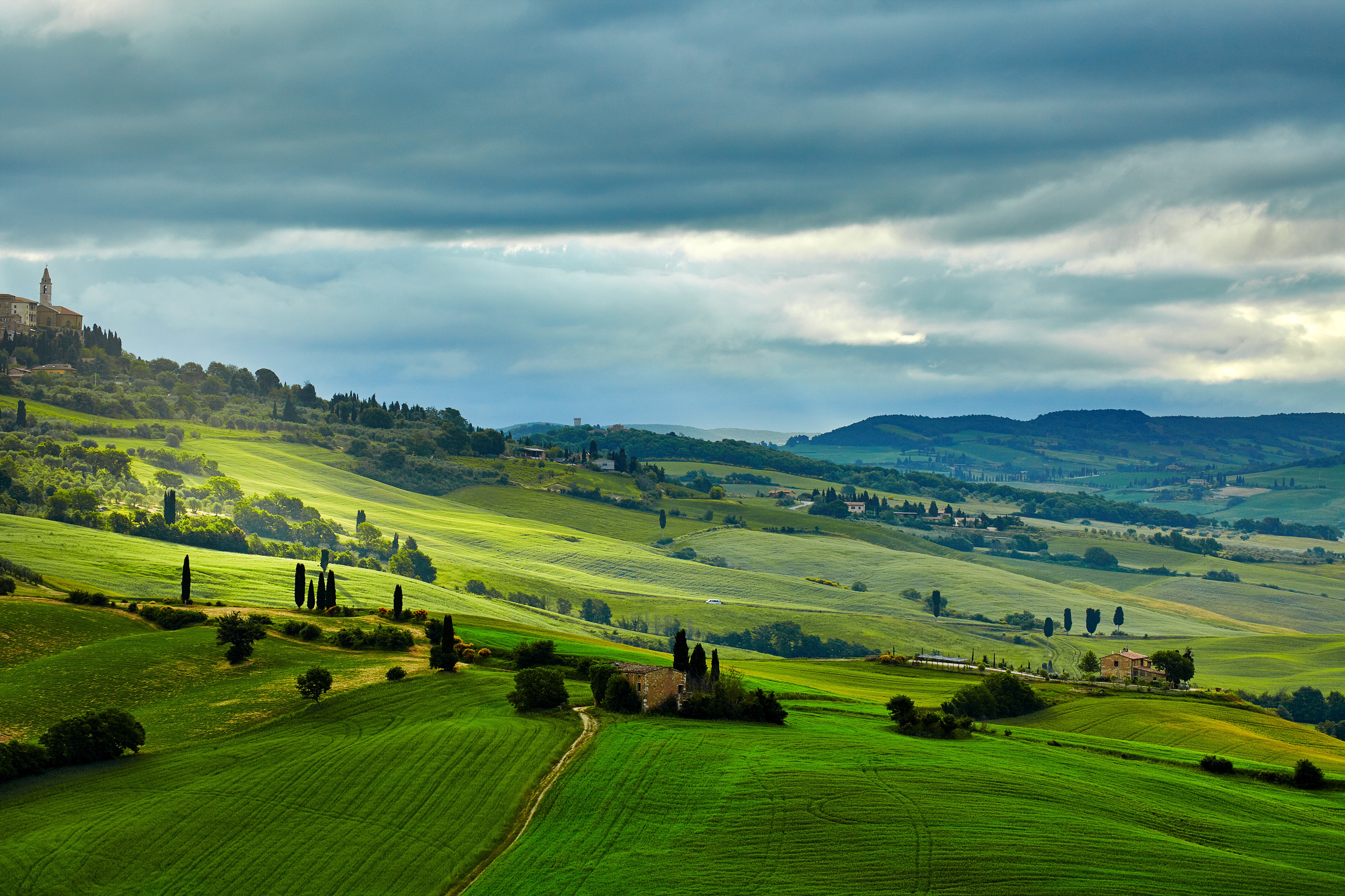 Tuscany landscape with rolling green hills and a village HD Wallpaper
