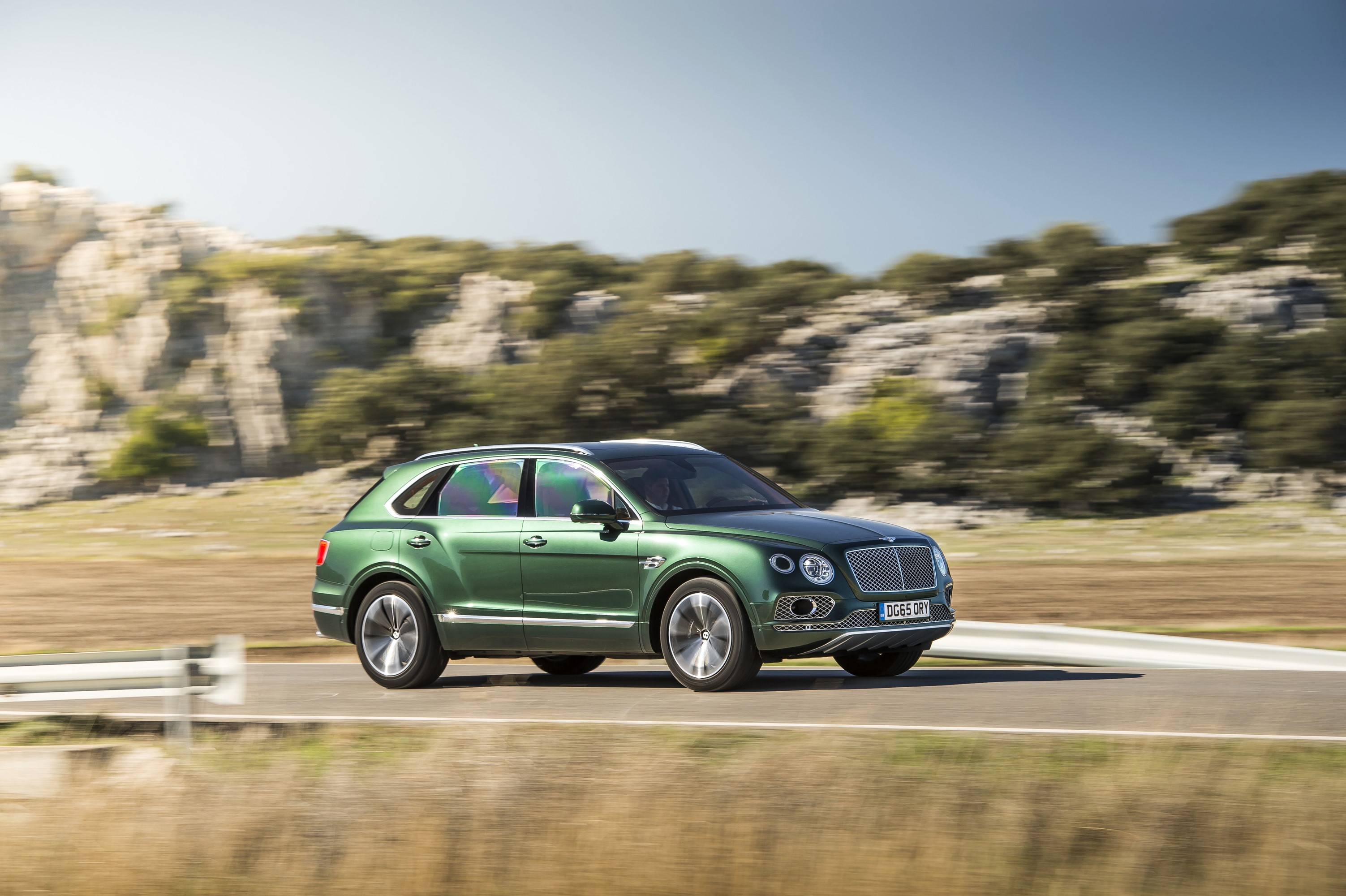 Green Bentley Bentayga driving on a road HD Wallpaper