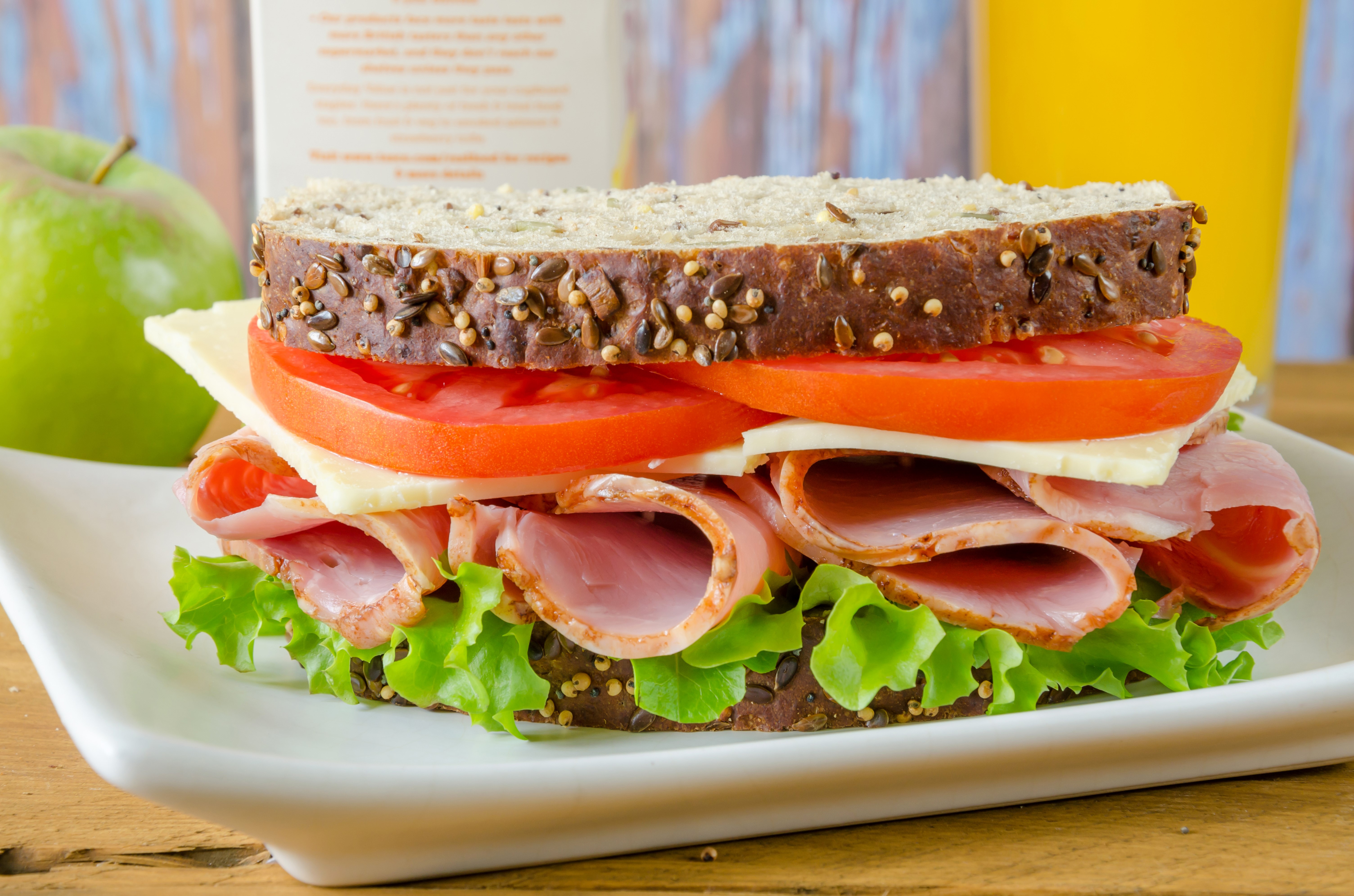 Ham and cheese sandwich with lettuce, tomato, and orange juice HD Wallpaper