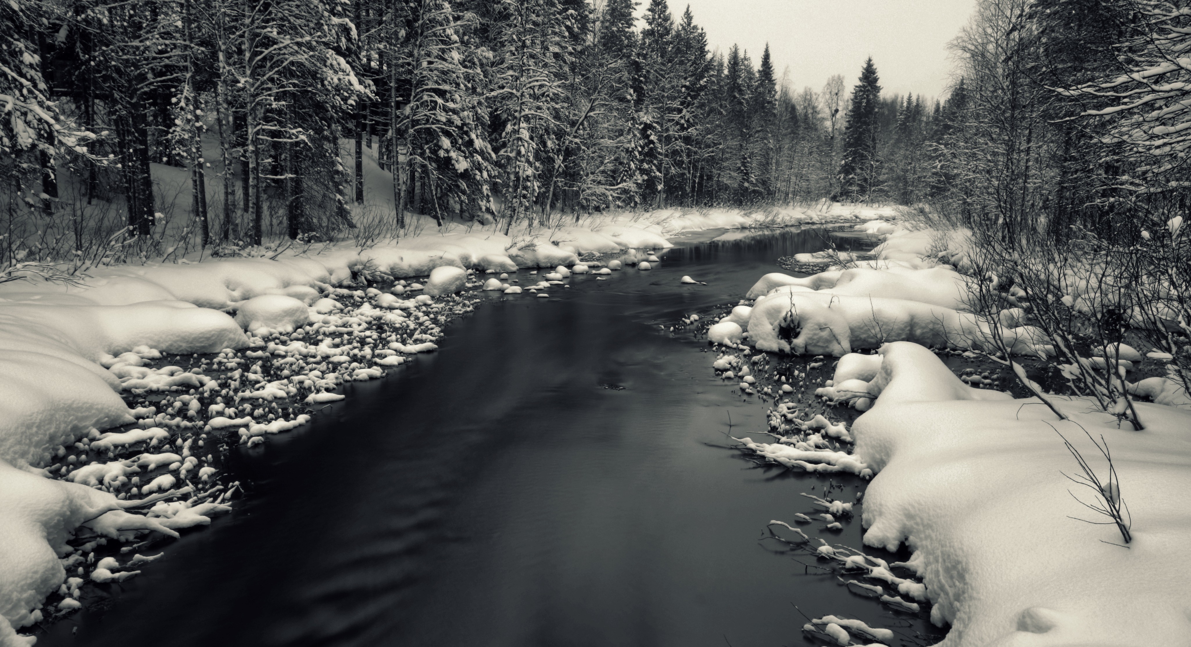 Winter river flowing through a snow-covered forest HD Wallpaper