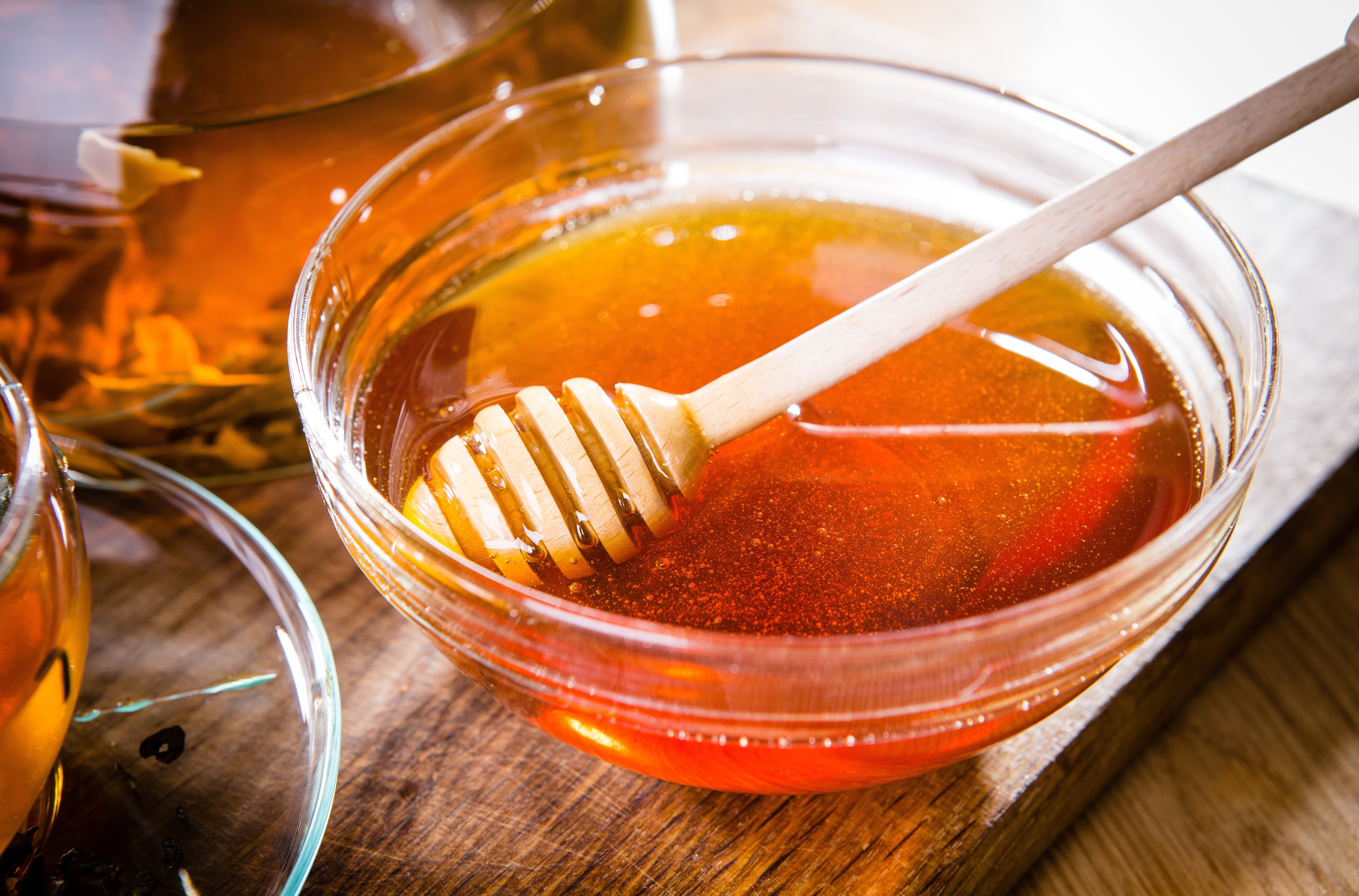 Honey in a bowl with a honey dipper HD Wallpaper