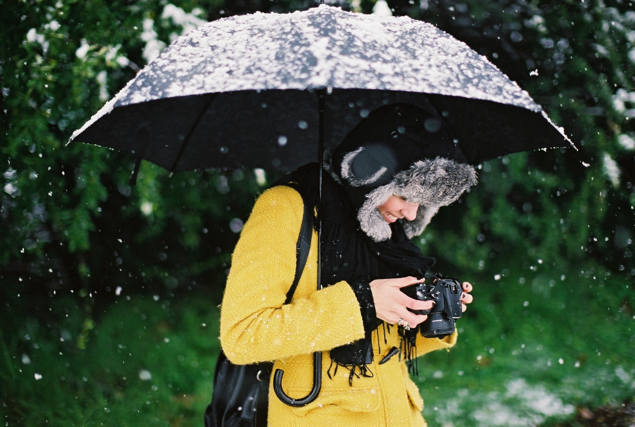 Woman with camera under umbrella in snow HD Wallpaper