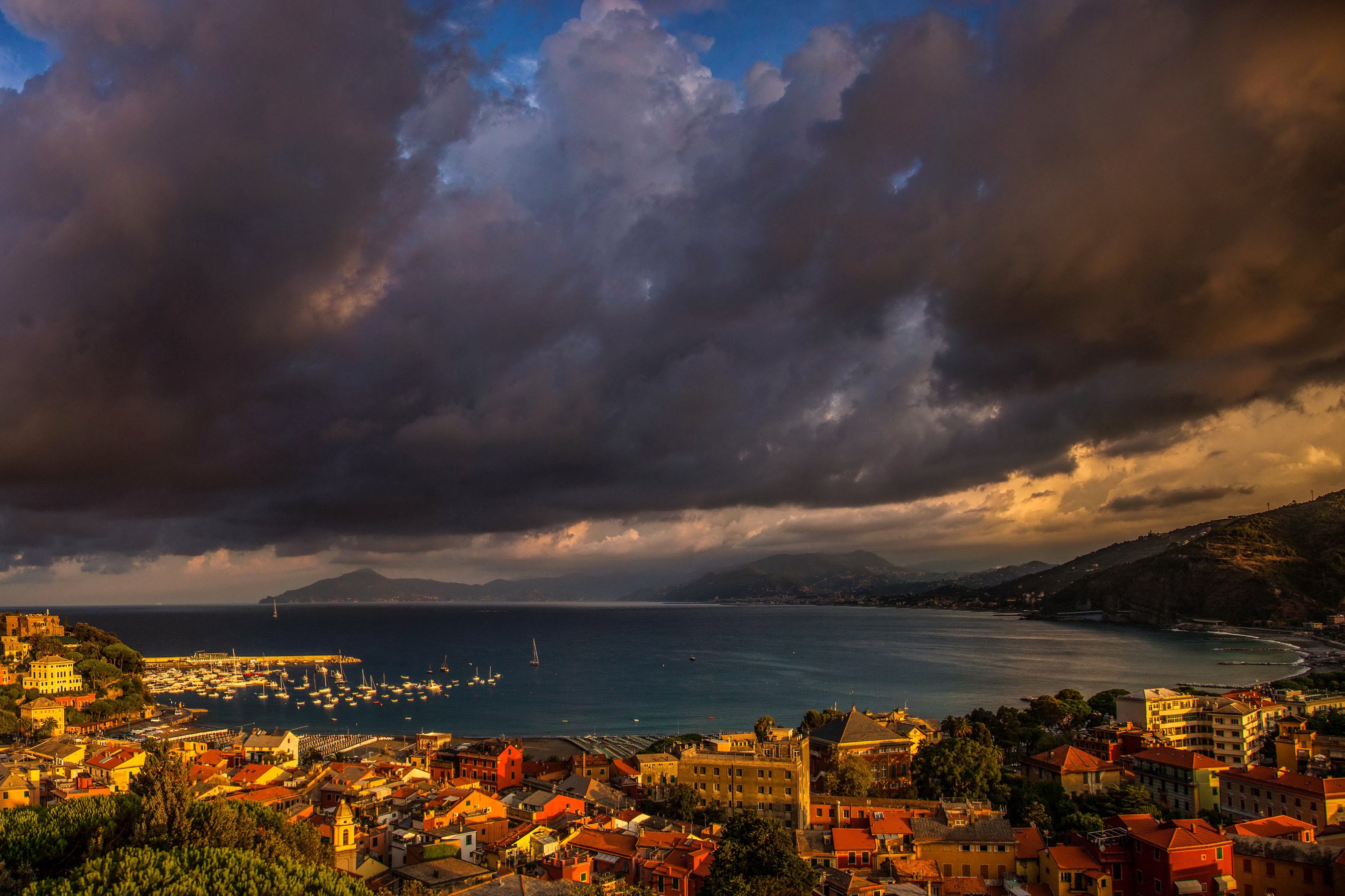 Coastal town with harbor and stormy clouds HD Wallpaper