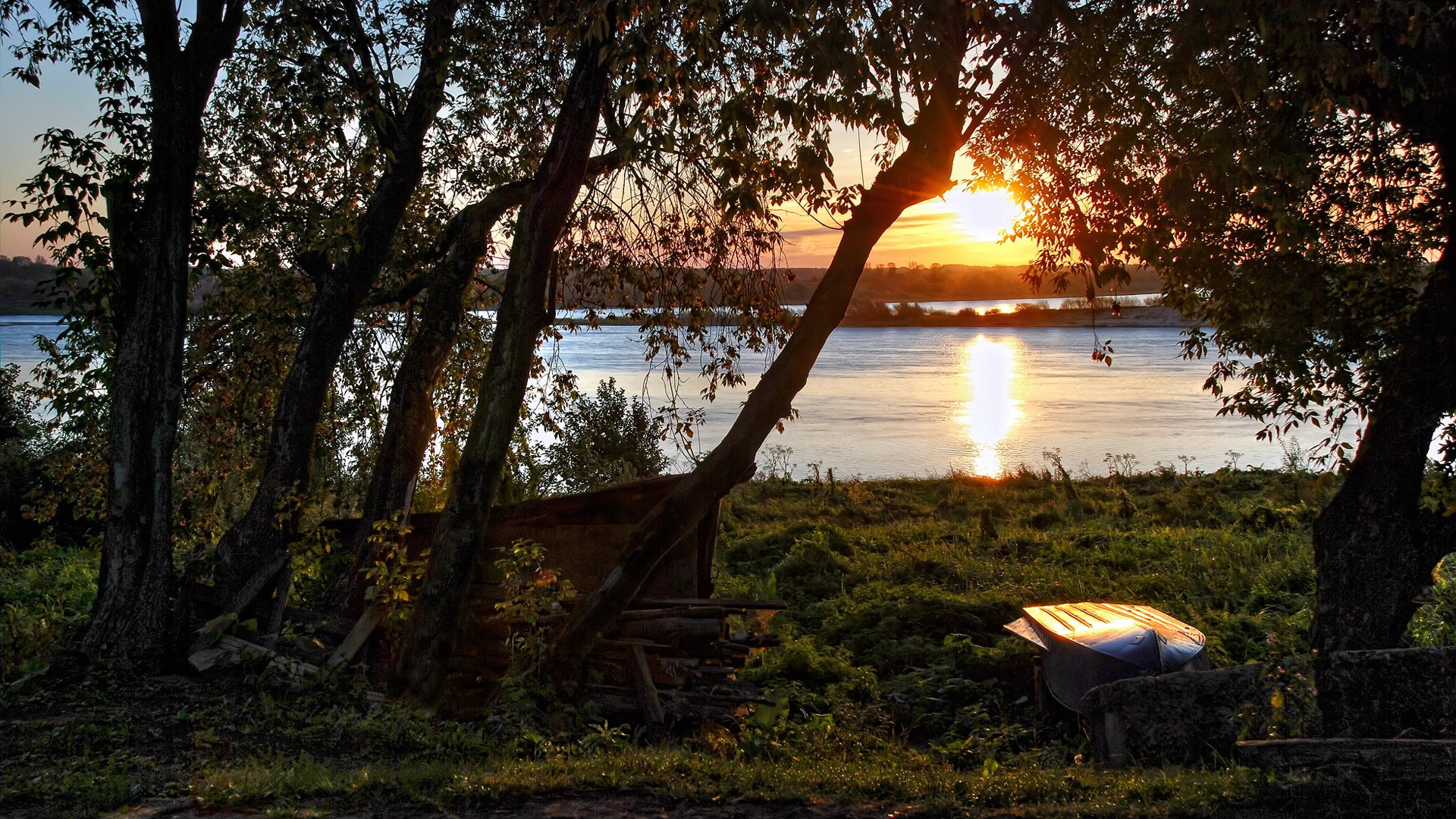 Sunset over a river with trees and a boat HD Wallpaper