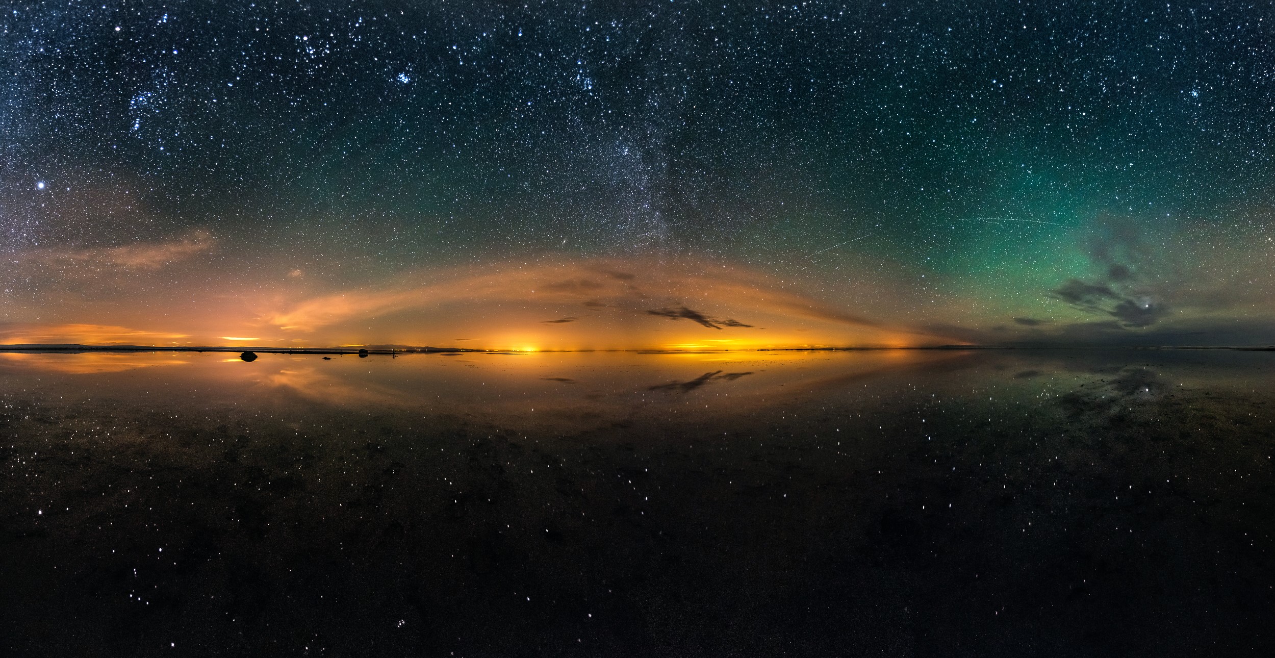 Night sky with stars and aurora over a reflective surface HD Wallpaper