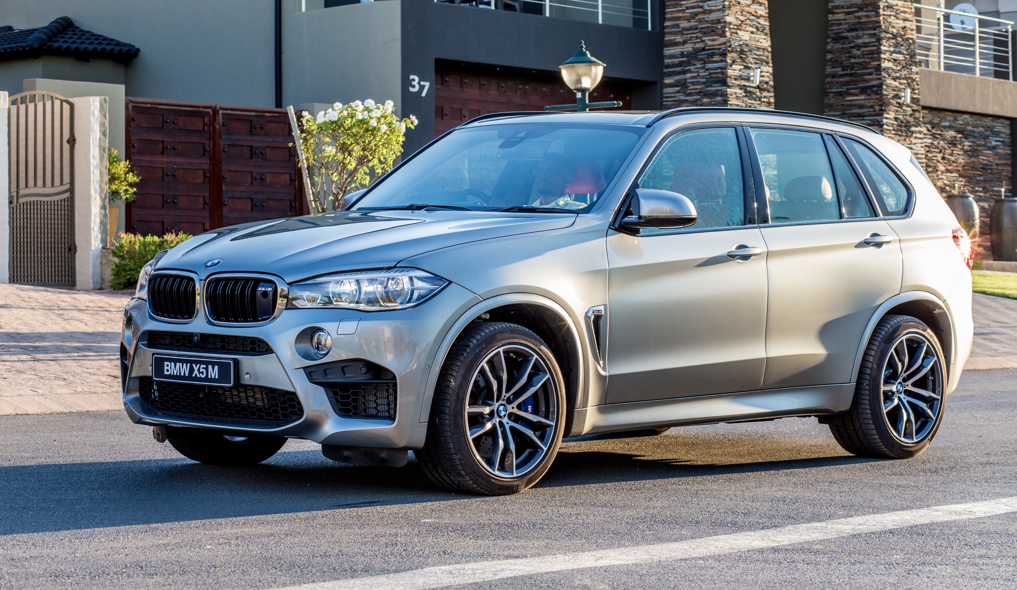 2015 BMW X5 M parked in front of a modern house HD Wallpaper