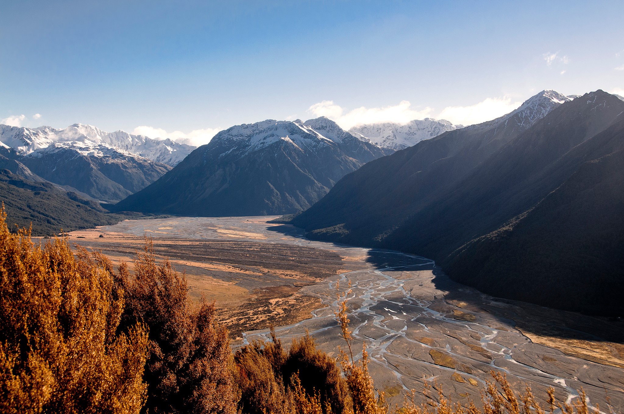 Snow-capped mountains and a braided river valley HD Wallpaper