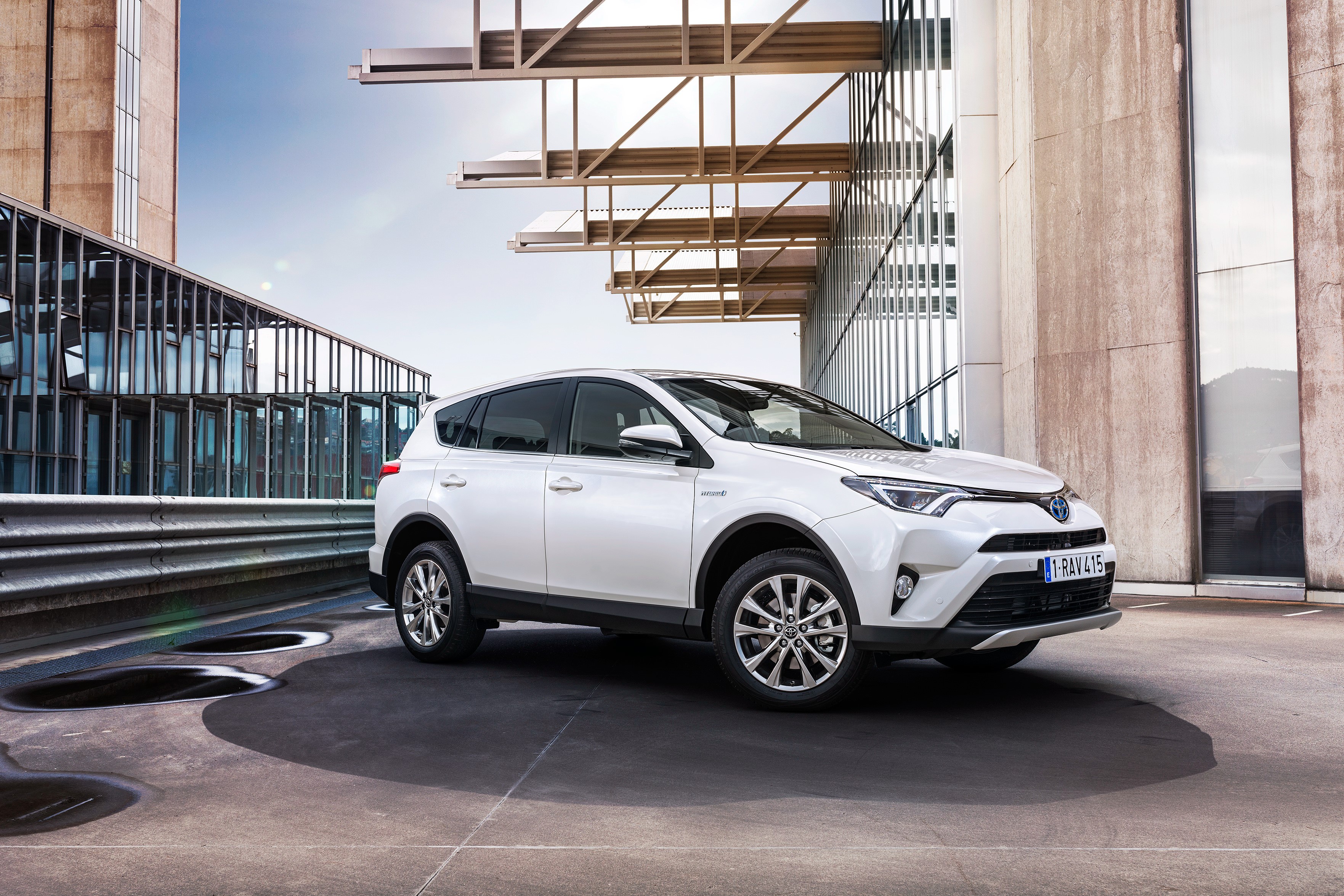 White Toyota RAV4 Hybrid parked outdoors HD Wallpaper