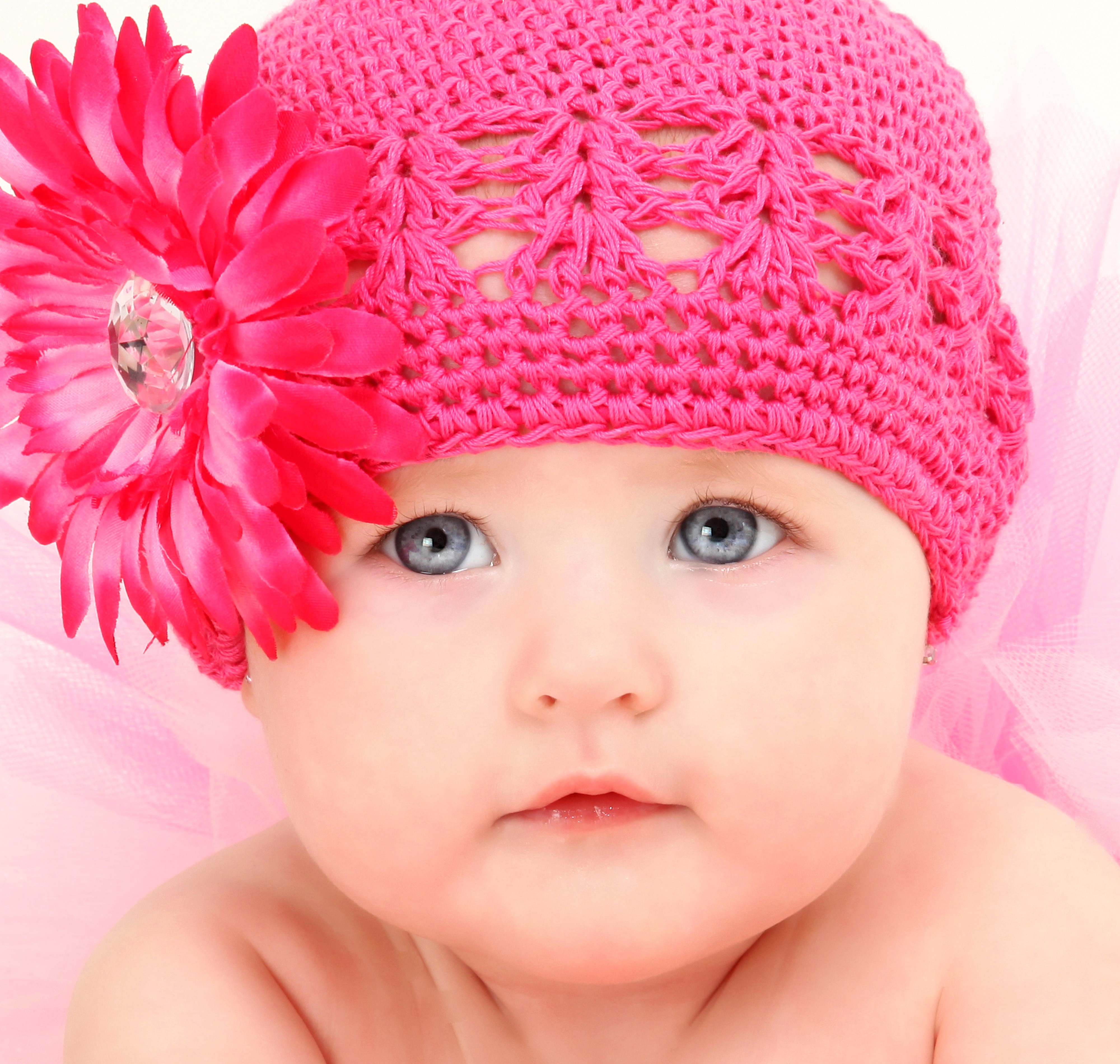 Baby wearing a pink knitted hat with a flower HD Wallpaper