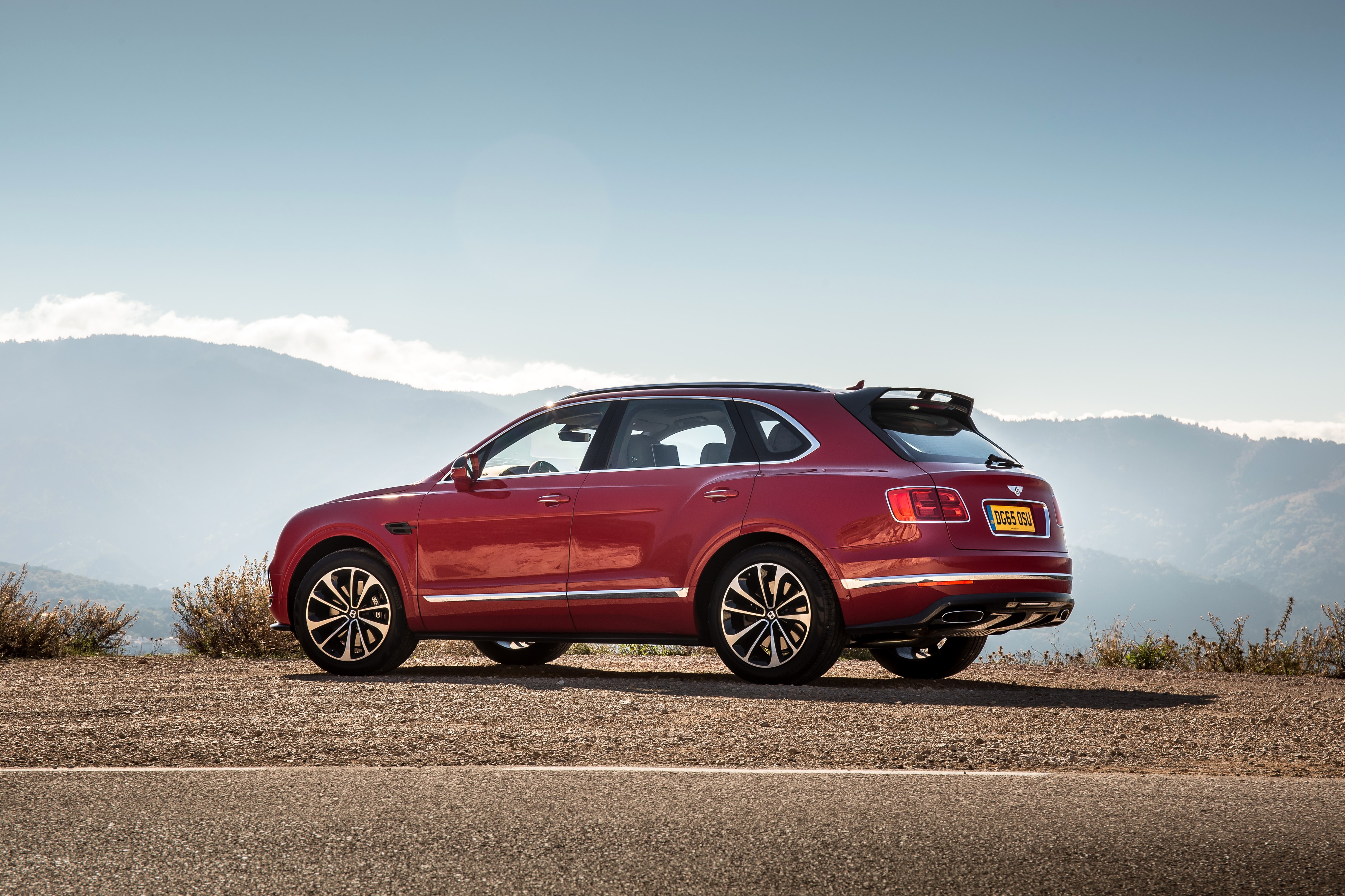 Red Bentley Bentayga parked on a dirt road HD Wallpaper